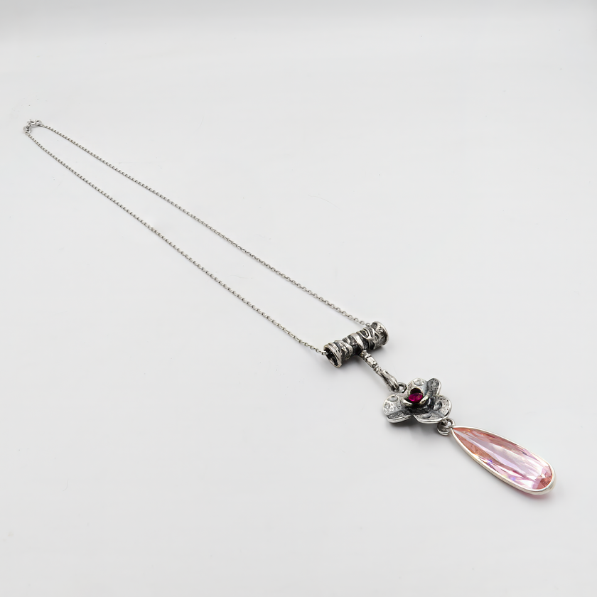 שרשרת עדינה וייחודית בסגנון רטרו, עם תליון כסף מעוטר בפרח תלת־ממדי ואבן ורודה כהה במרכזו. מטה ממנו נמתחת טיפה מוארכת בגוון שקוף ורדרד, המוסיפה מימד של תנועה וזרימה. העיצוב כולו משלב אלמנטים נשיים עם טאץ' אמנותי, ומתאים למראה ערב אלגנטי או כלה שמחפשת תכשיט לא שגרתי. מתאים גם כמתנה לנערה רומנטית ולחובבת עיצוב עם ניחוח מהעבר.

