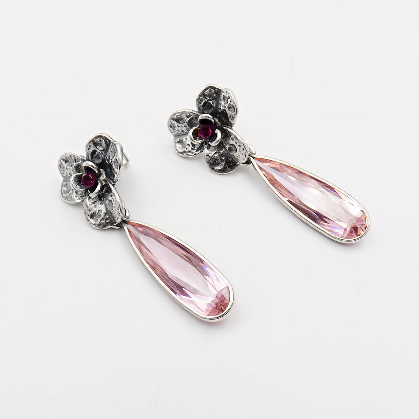 עגילים אלגנטיים בעבודת יד עם מוטיב של סחלב ורוד, משלבים צבע פסטלי עדין עם קווים רכים וזורמים, לתכשיט נשי, מרגש ומלא סטייל.