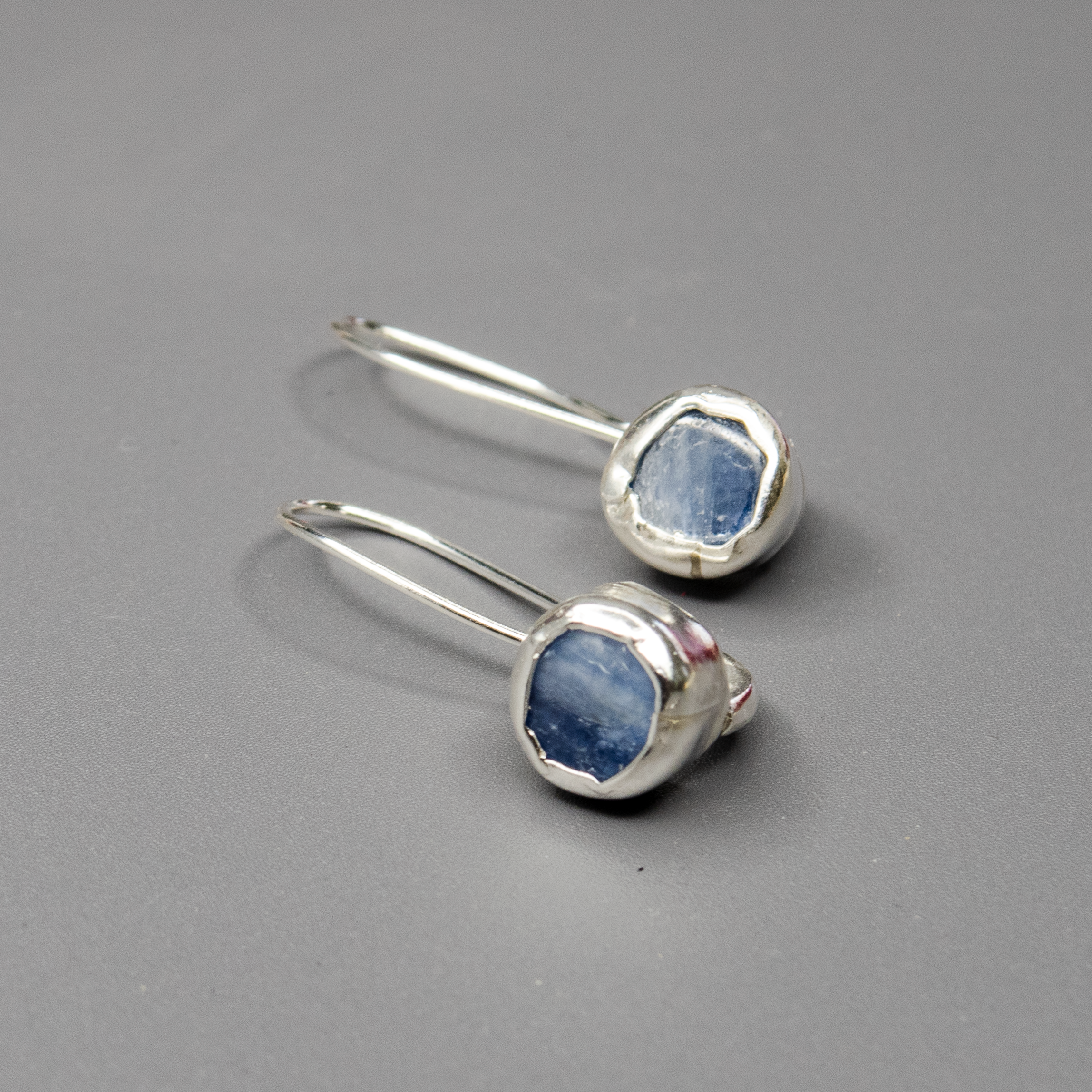 עגילי כסף בעבודת יד עם אבן קיאנייט טבעית בגוון כחול עמוק ומבריק. האבן משתלבת בעיצוב נקי ואורגני, עם נוכחות רגועה אך מרשימה. מתאימים לנשים שאוהבות תכשיטים באווירה טבעית, בעלי אנרגיה מיוחדת וסטייל אלגנטי. מושלם לשימוש יומיומי וגם לערב שקט ומוקפד.

