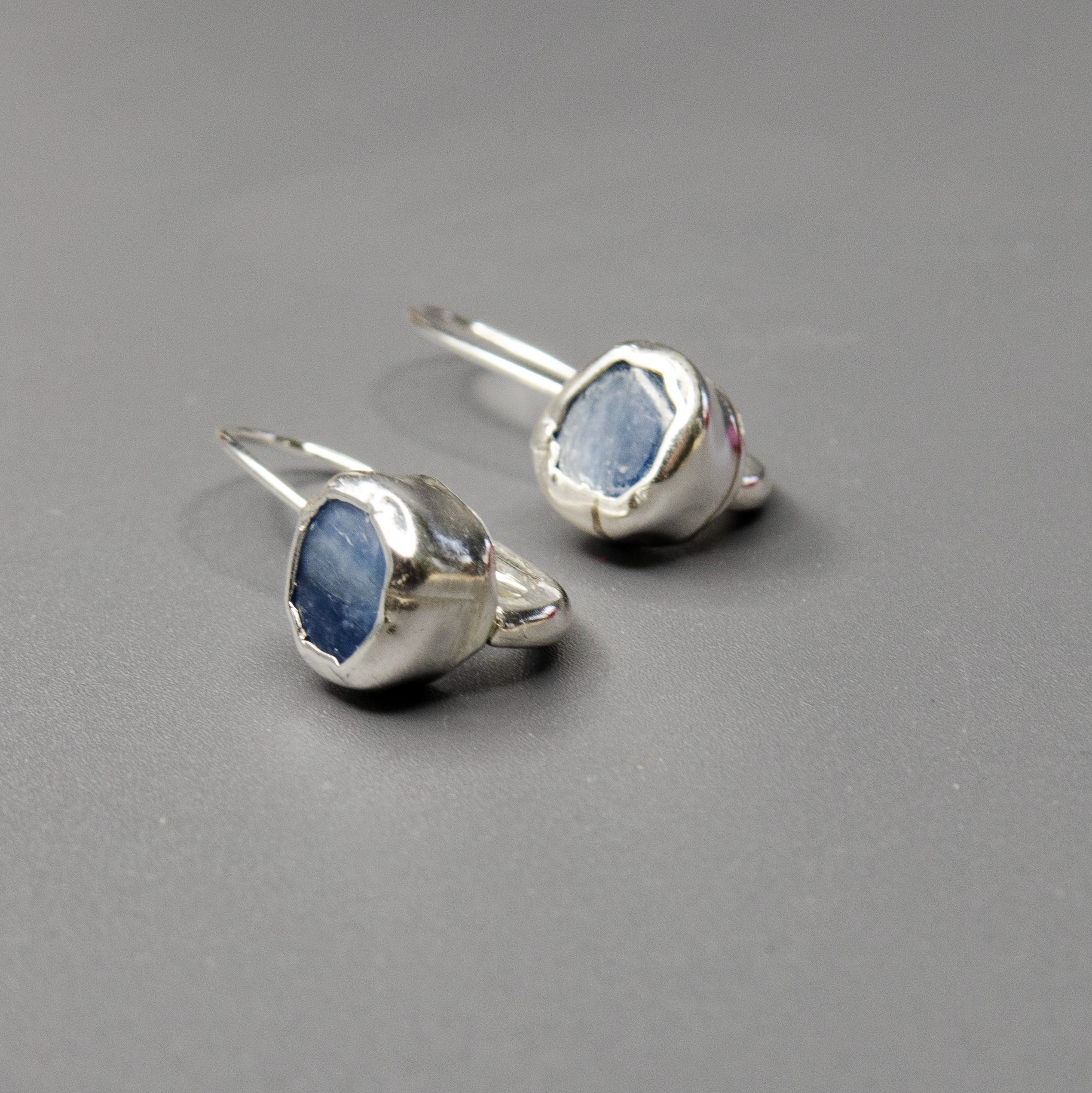 עגילים בעבודת יד עם אבני קיאנייט בגוון כחול שקוף-עמוק, המחוברות למסגרת כסף עדינה. שילוב בין עיצוב נקי לחומר גלם עוצמתי וטבעי. האבנים מוסיפות תחושת זרימה ושלווה, והכסף מדגיש את היופי של האבן. מתנה אידיאלית לאישה שמחפשת חיבור בין יופי לטבע.

