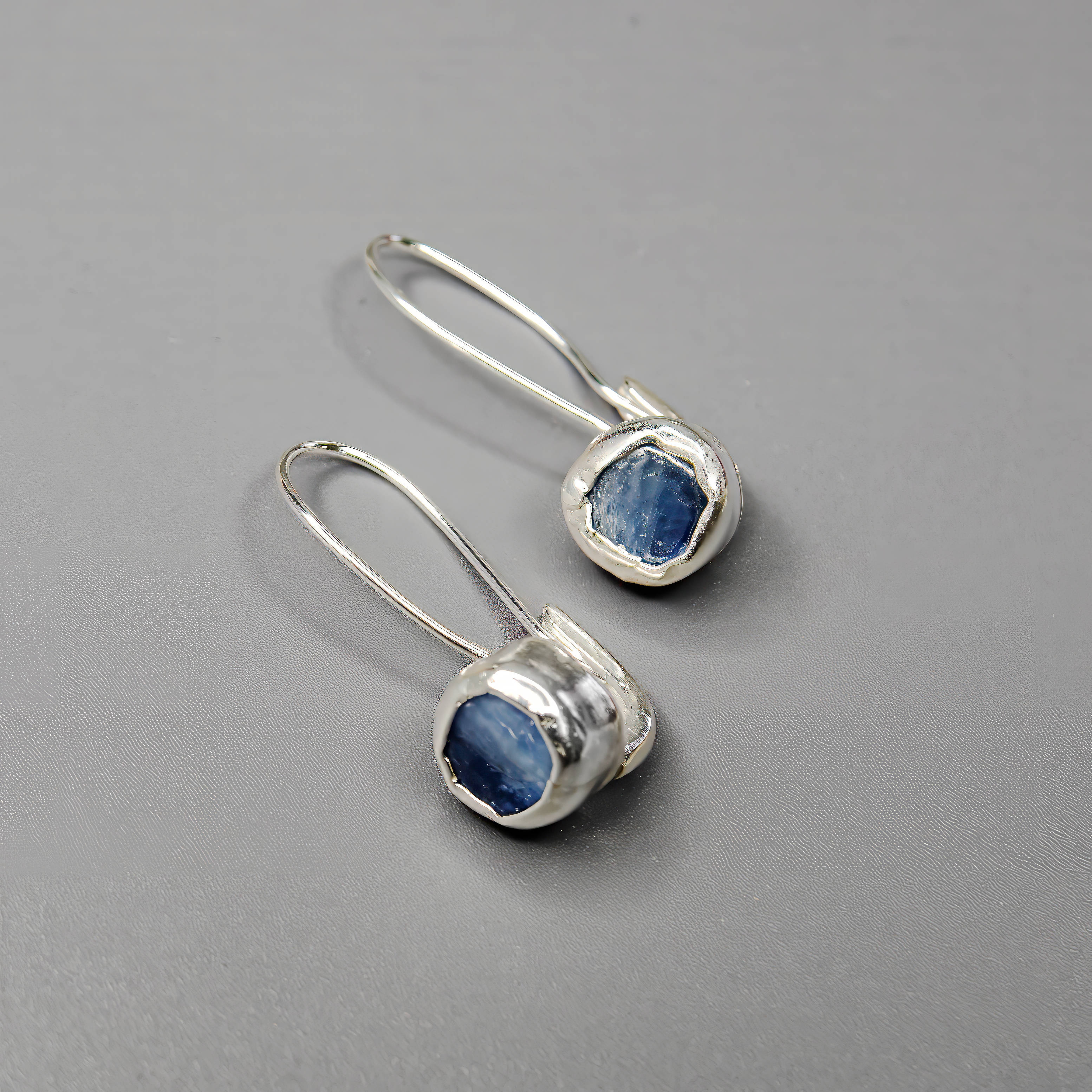 עגילי כסף אלגנטיים עם קיאנייט טבעי – תכשיט בעבודת יד שמשלב בין חוסן ועדינות. האבן הכחולה יוצרת מראה ייחודי ואישי, ומתאימה למי שאוהבת צבעים עמוקים עם נוכחות שקטה. עגילים קלילים ונוחים ללבישה, שמוסיפים ברק כחול עמוק לכל הופעה.

