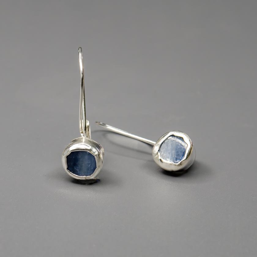 עגילים מכסף סטרלינג בעיצוב עדין וייחודי, משובצים באבן קיאנייט כחולה בגוון שמחליף טונים באור. כל זוג עגילים עשוי בעבודת יד באהבה ובדיוק. תכשיט שמשלב אנרגיה רוחנית, צבע מעודן ואלגנטיות שקטה – מתאים לנשים עם טעם אישי מדויק ונגיעה של עומק.

