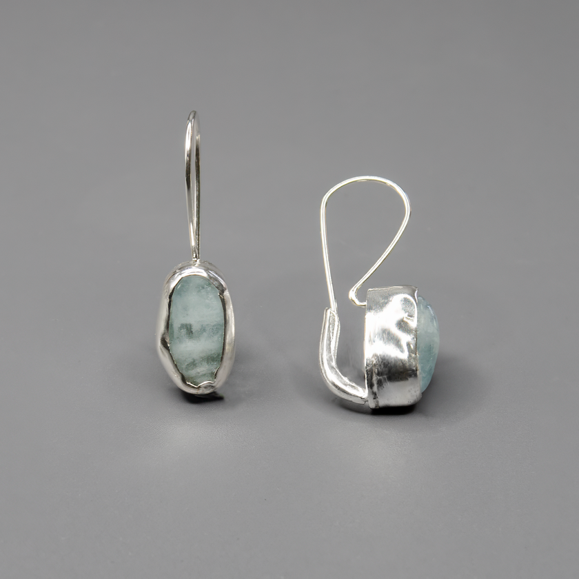 עגילי כסף בעבודת יד עם אבן אקוומארין אמיתית. האבן הכחולה-שקופה מוסיפה מגע עדין, נקי ורומנטי. תכשיט שמתחבר ליופי הפנימי ומשדר רוגע. מתאים לנשים שאוהבות טבע, תכשיטים בעלי נוכחות אלגנטית ומראה קלאסי שאינו חולף מהאופנה.

