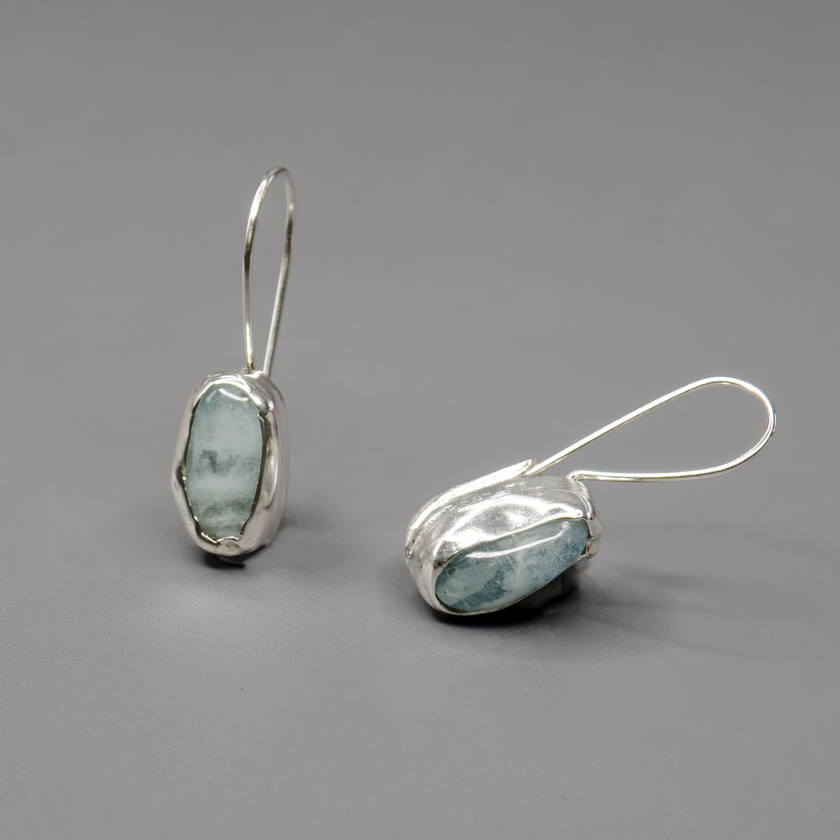 עגילים בעיצוב עדין מכסף סטרלינג עם אבן אקוומארין טבעית בגוון תכלת שקוף. עבודת יד מוקפדת שמשלבת בין יופי טבעי לקווים נקיים ואלגנטיים. האבן מוסיפה רוגע וברק רך, והעגיל מתאים ליום-יום או לערב שקט. מתנה מושלמת לנשים שאוהבות תכשיטים עם אופי רגוע ותחושת טוהר.

