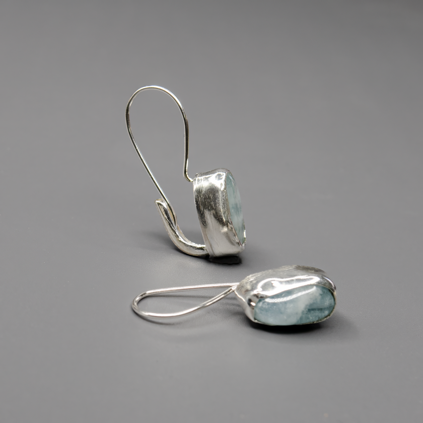 עגילים תלויים מכסף טהור עם אבן אקוומארין אמיתית, בגוון שמיים שקוף ורך. עיצוב בעבודת יד שמשלב טבע עם אלגנטיות שקטה. האבן מסמלת שלווה ואיזון רגשי. מושלמים לשימוש יומיומי או לערב רגוע עם מראה עדין, נשי ונעים.

