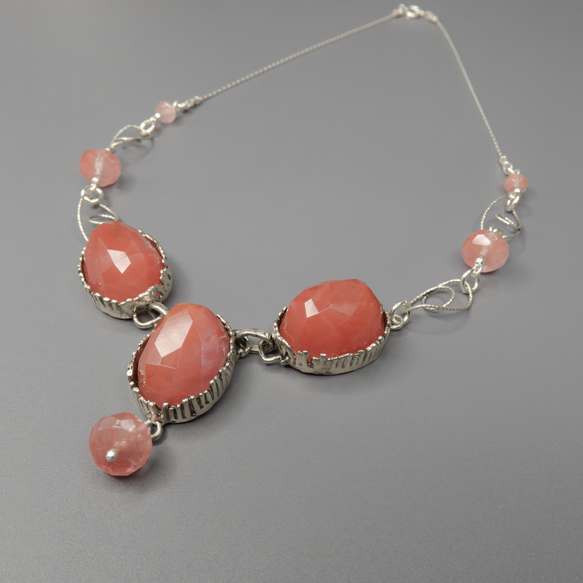 שרשרת ענק מכסף טהור בעיצוב מעודן ומשולב עם אבני צ'רי קוורץ בגוון ורוד שקוף-עמוק ואופלית בעלת נצנוץ חלבי-רוחני. האבנים נבחרו בקפידה ליצירת איזון בין חמימות ורודה לאור רך ופנינתי. האופלית מוסיפה נגיעה של קסם וחלום, בעוד שהצ’רי קוורץ נחשב לאבן של אהבה עדינה והתחדשות רגשית. תכשיט שמתאים לכל עונה ומעורר תחושת נשיות, חמלה ואלגנטיות. תוספת נהדרת לאוסף התכשיטים של כל אישה שמעריכה יופי טבעי ועבודת יד איכותית.


