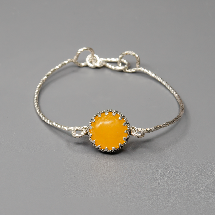 צמיד קשיח מכסף סטרלינג 925 בעבודת יד, משובץ באגת צהובה בגוון חמימה ובהיר. העיצוב הנקי מאפשר לאבן להיות במרכז הבמה – צבעה משתלב נפלא עם עור בהיר או כהה ומאיר את הלוק כולו. תכשיט שמחבר בין פשטות לרעננות, מתאים ליום יום, לאירועים או כמתנה עם אנרגיה חיובית. מושלם לנשים שאוהבות שילוב של טבע וסטייל.

