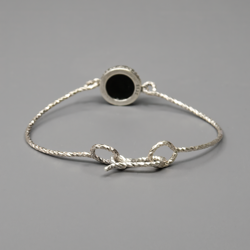 צמיד כסף בעיצוב נוקשה ונקי, משובץ באבן אוניקס בגוון שחור עמוק ומבריק. עבודת יד קפדנית עם תשומת לב לפרטים הקטנים. האוניקס מעניק מראה עוצמתי, מאוזן ואלגנטי. הצמיד נוח לענידה, קל לשילוב עם תכשיטים נוספים ומתאים גם לסגנון בוהו-שיק וגם למראה יוקרתי ומוקפד. בחירה מושלמת לאישה שמחפשת תכשיט עם עוצמה פנימית ונוכחות שקטה.

