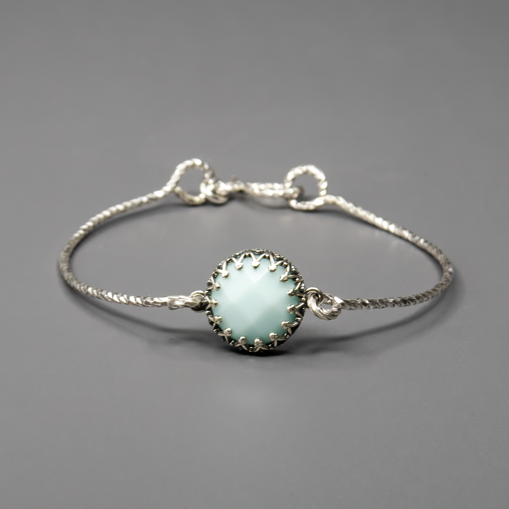 צמיד כסף קשיח ואלגנטי, משובץ באבן אופליט בגוון לבן-תכלת חלומי, בעבודת יד מוקפדת. האבן מחליפה גוונים קלות בהתאם לאור ומוסיפה לתכשיט מראה מרגיע, נקי ומרענן. הצמיד עשוי מכסף סטרלינג 925, בעיצוב מינימליסטי ונוח לענידה. תכשיט שמושך את העין בעדינות, מתאים לשילוב עם לוק יומיומי או לבוש ערב. מתנה מושלמת לאישה שאוהבת עיצוב מודרני עם טאץ' קסום ונשי. הבחירה האידיאלית למי שמחפשת יופי שקט וייחודי.

