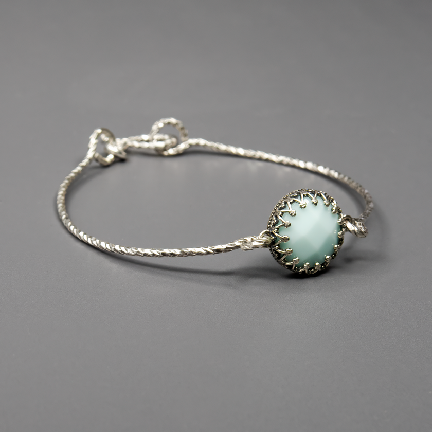 תכשיט עם נוכחות אלגנטית – צמיד כסף קשיח בעיצוב נקי ומודרני, משובץ באופליט בגוון לבן-תכלת עם ברק פניני רך. האבן הסינתטית יוצרת אפקט עדין של אור וזוהר פנימי, ומעניקה תחושת רוגע וחיבור פנימי. הצמיד מתאים במיוחד לאירועים חגיגיים, למתנות יום הולדת או סתם כפינוק עצמי. מתאים לנשים שמעריכות תכשיטים בעיצוב מתוחכם אך רגוע. גימור מדויק, איכות גבוהה ונוחות מרבית.

