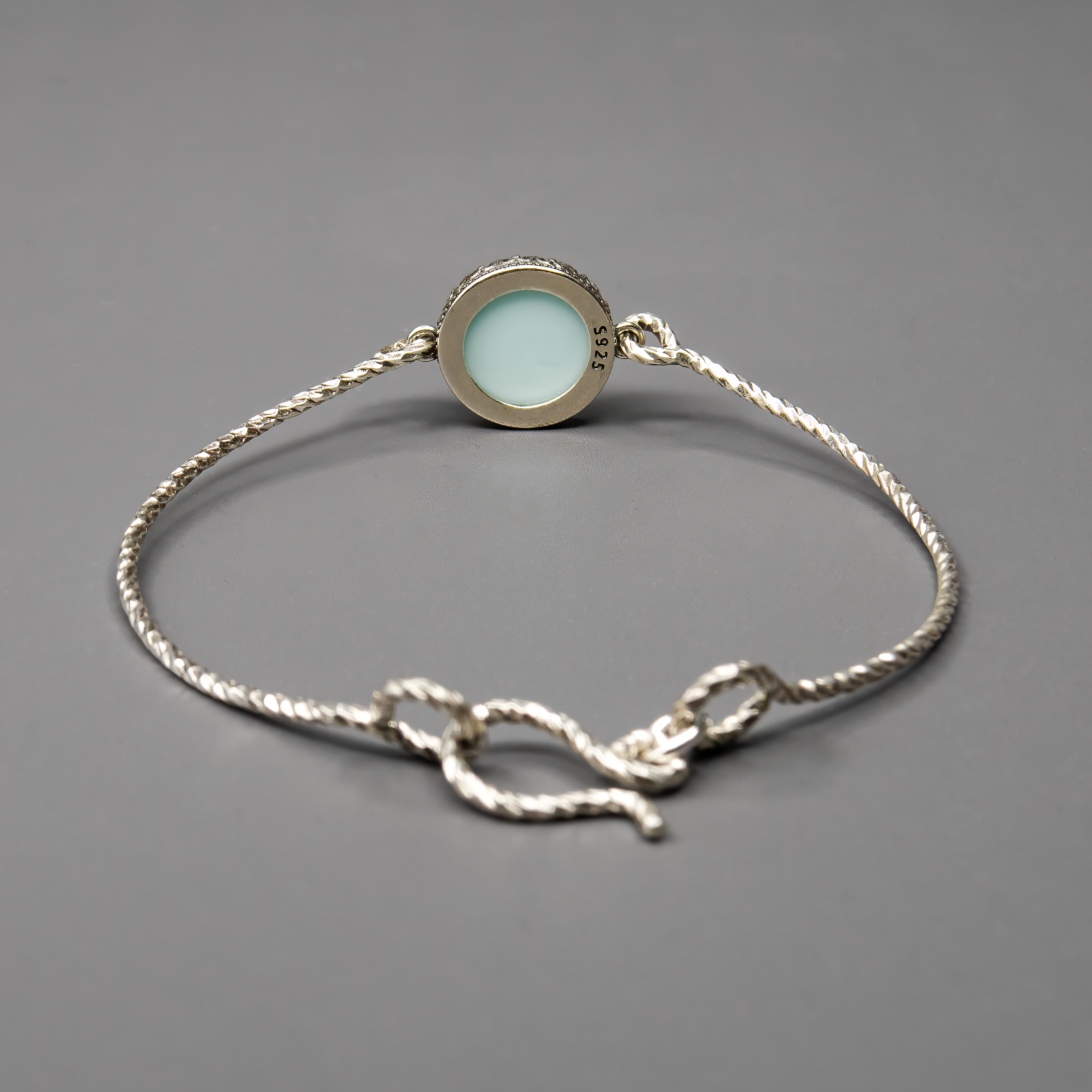 צמיד כסף בעיצוב קשיח עם שיבוץ של אופליט לבן-תכלת – אבן סינתטית ייחודית המשלבת מראה חלבי עם רמיזות קלות של כחול שמיים. האבן יוצרת מראה רגוע, טהור וקסום, שמתאים לסגנון בוהו מודרני או עיצוב רומנטי מינימליסטי. הצמיד מתאים במיוחד לכלה, לשושבינה, או למתנה עם משמעות. תכשיט על-זמני שניתן לשלב עם תכשיטים נוספים או לענוד לבד כמוקד עדין של תשומת לב.

