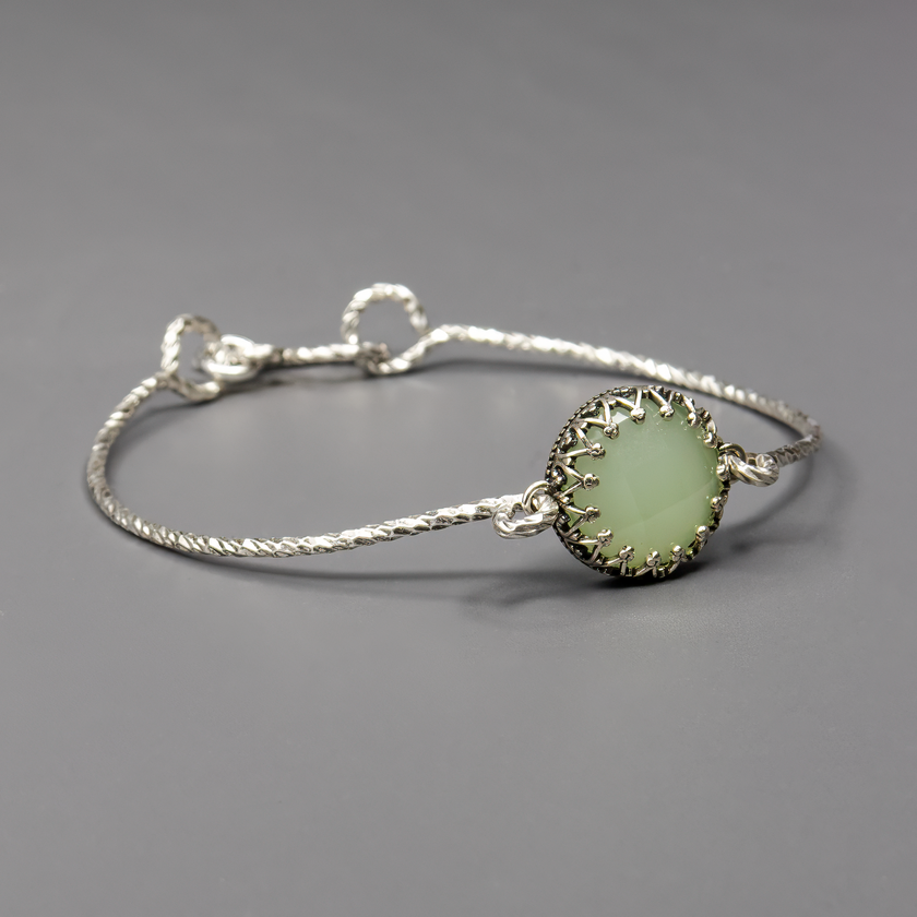 צמיד כסף נוקשה משובץ אופליט ירוק – שילוב של עוצמה ועדינות. האבן הירוקה משקפת אור באופן רך וייחודי, בעוד מבנה הצמיד מדגיש קווים נקיים ומודרניים. עיצוב שמתאים גם למראה קלאסי וגם לסגנון עכשווי, עם גימור מוקפד ואיכות גבוהה.

