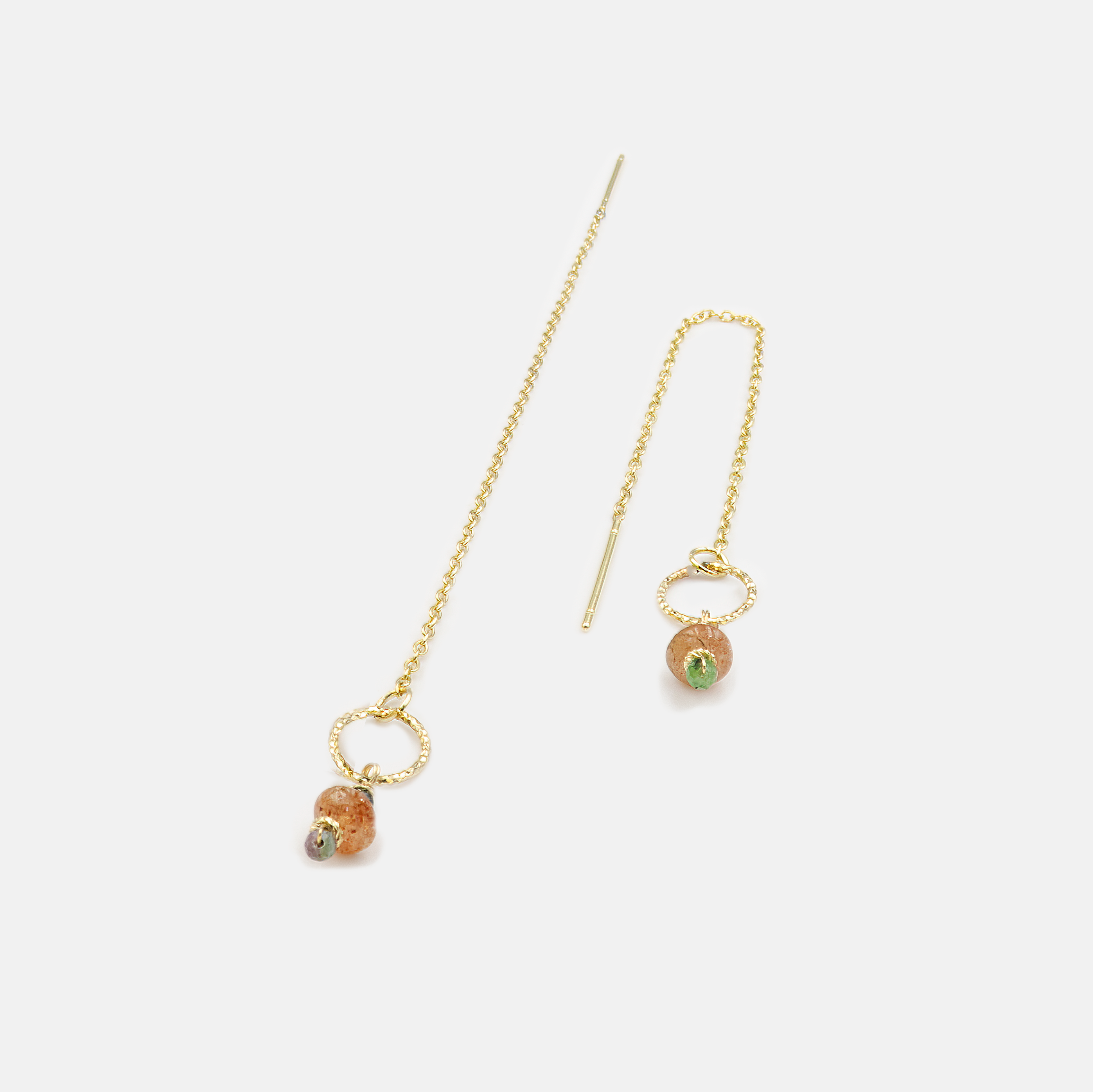 עגילי שרשרת יוקרתיים עם צ'ארמים של זוייסייט ירקרקה וסנסטון קורן, תלויים על זהב 14 קראט מבריק. תכשיט שמשלב חום, חיוניות ורכות – האבנים נעות בתנועה חופשית ומוסיפות תחושת טבע חיה ומודרנית. מתאים למראה יומיומי עם טוויסט, או להופעה שיקית בערב קיץ.

