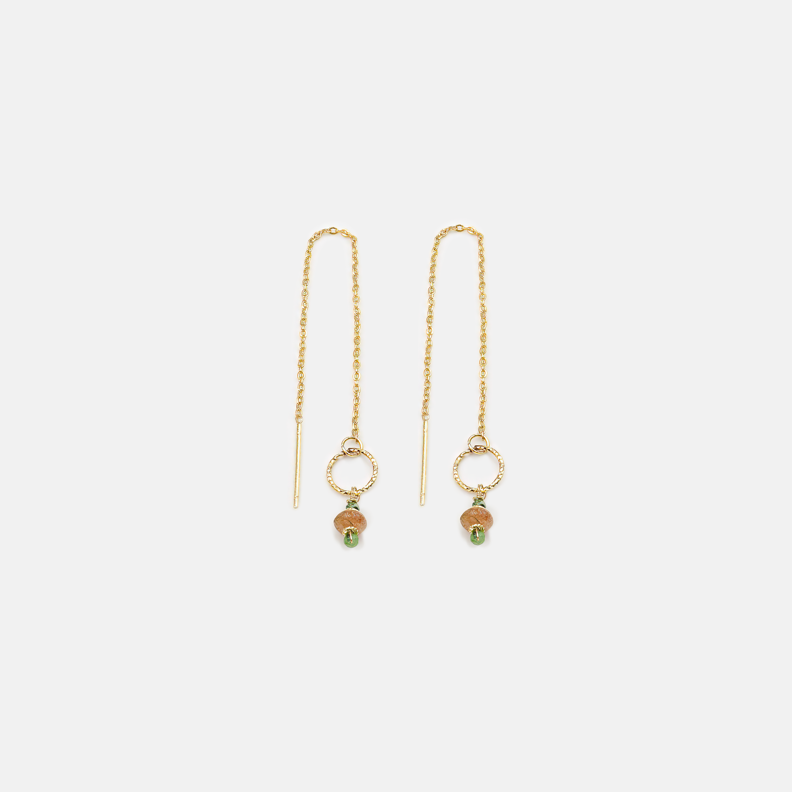 עגילי תלייה קלילים מזהב 14 קראט עם תליונים של אבני זוויסייט טבעית וסנסטון מנצנצת. שילוב נדיר של ירוק עמוק עם כתום זהוב שקוף – מראה יוצא דופן ומלא אופי. תכשיט בעבודת יד שמתאים לנשים שאוהבות סטייל נועז אך הרמוני, טבעי אך מעודן.

