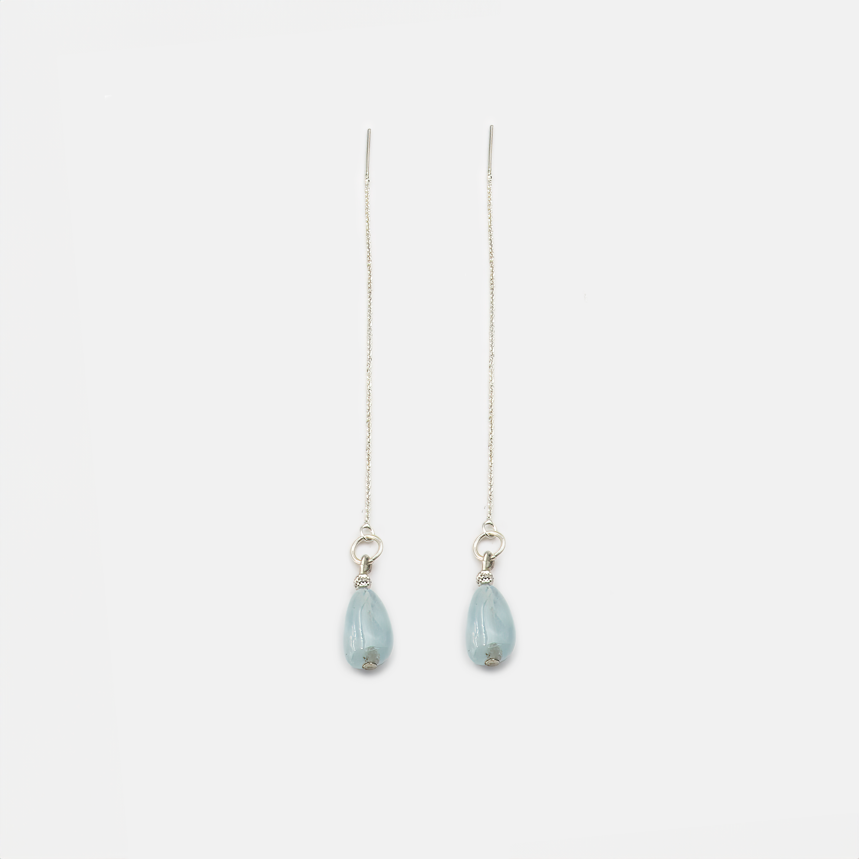 עגילי שרשרת קלאסיים בעיצוב עכשווי, עם תליון אקוומרין טבעי שמשתלב בזהב לבן 14 קראט. התוצאה: תכשיט שמתאים גם למראה ערב מתוחכם וגם ליום-יום עם טאץ’ של זוהר. האקוומרין מקרין רוגע ואיזון, והעיצוב הנקי מביא לידי ביטוי את יופיו של החומר הטבעי. מתנה נהדרת או פינוק אישי – תכשיט שמביא עמו תחושת שלווה פנימית ונוכחות שקטה.