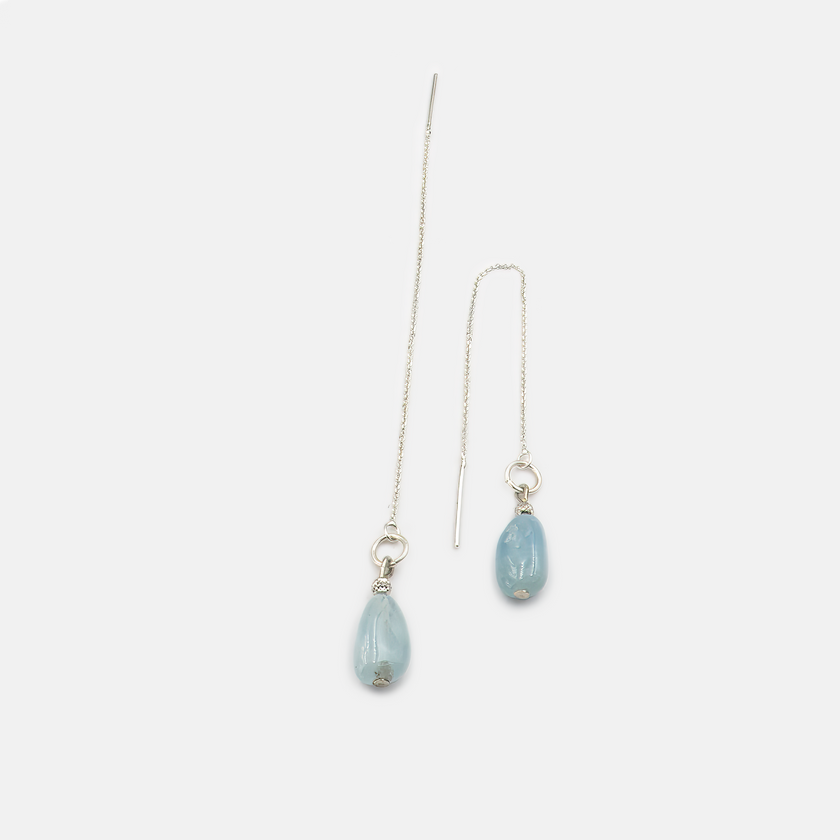 עגילי שרשרת בזהב לבן 14 קראט עם אבן אקוומרין טבעית, תכשיט שמזכיר את רכותו של האוקיינוס בשעות הבוקר המוקדמות. האבן התכולה זורחת באור פנימי עדין, נעה ברכות עם כל תזוזה, ומעניקה לעונדת תחושת שקט, ניקיון ואלגנטיות טבעית. עיצוב נעים לעין אך מלא אופי, מושלם ללבישה יומיומית עם נגיעה של יוקרה מתוחכמת.