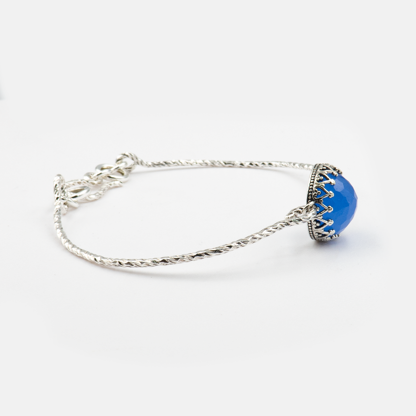 צמיד כסף סטרלינג קשיח, משובץ באופלית כחולה – אבן סינתטית מרהיבה בצבעי כחול-אינדיגו משתנים. הצמיד נועד לנשים שאוהבות תכשיטים בעיצוב מדויק עם נגיעה של קסם. מתאים לשילוב עם בגדים בצבעים טבעיים, ג'ינס או שמלת ערב. האבן מביאה עמה תחושת שקט פנימי ויופי מהפנט. תכשיט שמשלב אלגנטיות קלאסית עם גישה עכשווית.

