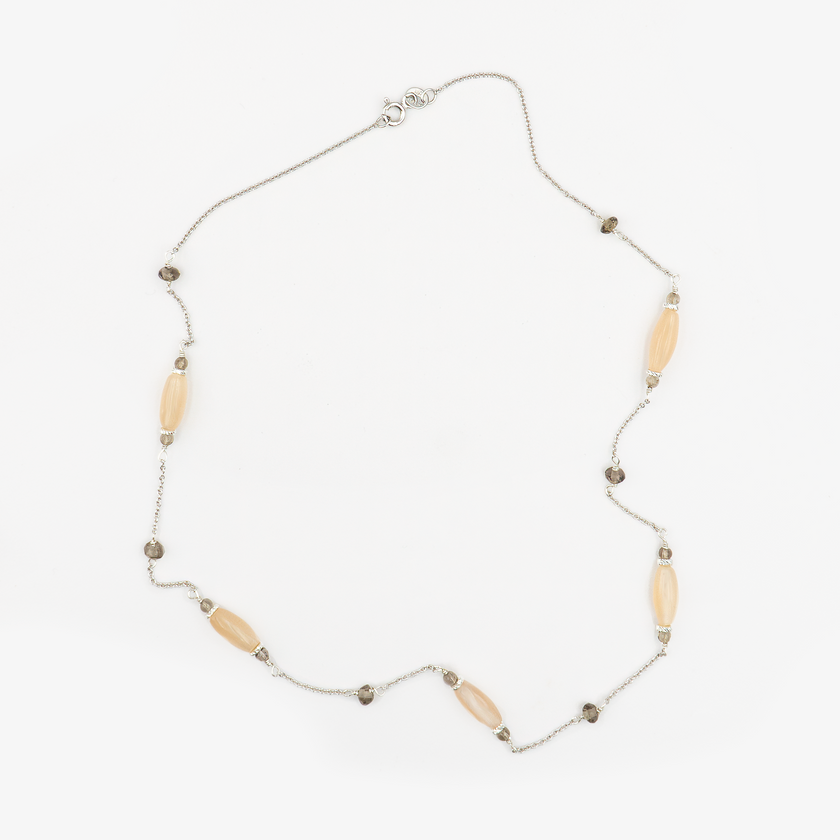 שרשרת זהב 14 קראט מעוצבת בקווים עדינים ומוקפדים, המשובצת בשתי אבני חן טבעיות ייחודיות: טופז שקוף עם ברק קריסטלי נוצץ ומונסטון פנינתי בגוון עדין וחלק שמקרין אור פנימי רך ומסתורי. השילוב בין הברק הקריסטלי של הטופז והזוהר הפנימי של המונסטון יוצר ניגוד מיוחד בין אור וצל, ונותן לתכשיט מראה אלגנטי, עדכני ומתוחכם. השרשרת מתאימה לשימוש יומיומי, אך גם להשלמת מראה ערב נוצץ וייחודי, ומעניקה ללובשת תחושת נוכחות רגועה עם נגיעות של זוהר טבעי.

