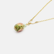 A necklace with a bead pendant in shades of green