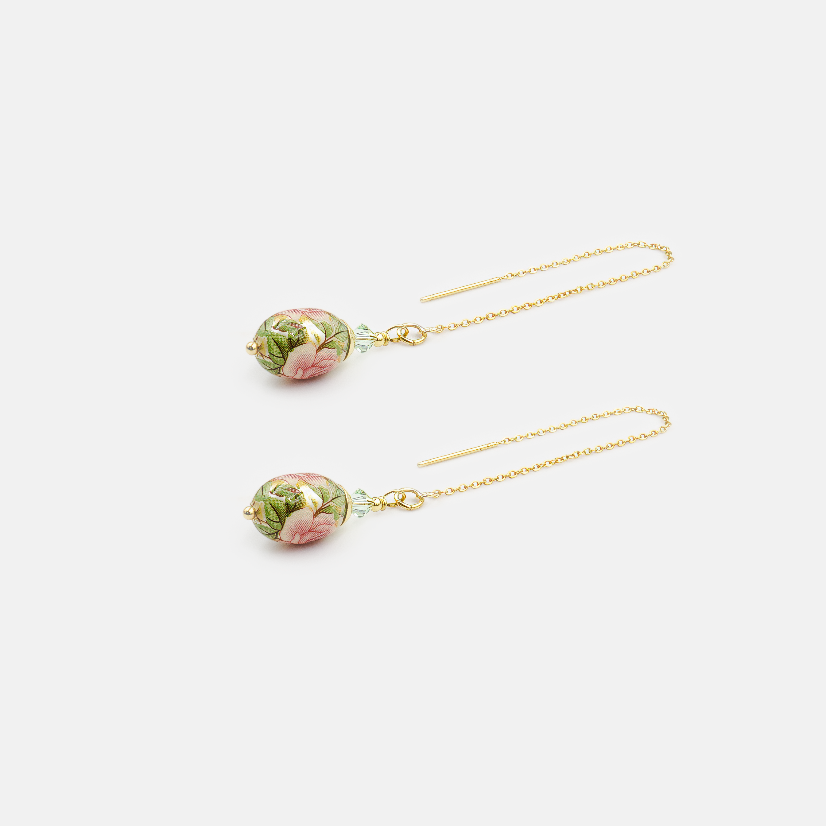 עגילי שרשרת תלויים עם חרוז אמייל בגוון ירוק בהיר, בעיצוב אוורירי ונשי במיוחד. השרשרת הדקה יוצרת תנועה אלגנטית סביב הפנים, והחרוז הירוק מוסיף נקודת צבע עליזה ומעודנת. מתאימים למראה יומיומי עם נגיעת רעננות, או כתוספת קלילה לשמלה חגיגית.

