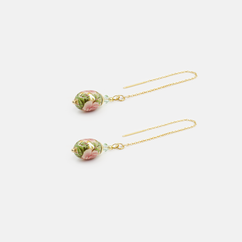 עגילי שרשרת תלויים עם חרוז אמייל בגוון ירוק בהיר, בעיצוב אוורירי ונשי במיוחד. השרשרת הדקה יוצרת תנועה אלגנטית סביב הפנים, והחרוז הירוק מוסיף נקודת צבע עליזה ומעודנת. מתאימים למראה יומיומי עם נגיעת רעננות, או כתוספת קלילה לשמלה חגיגית.

