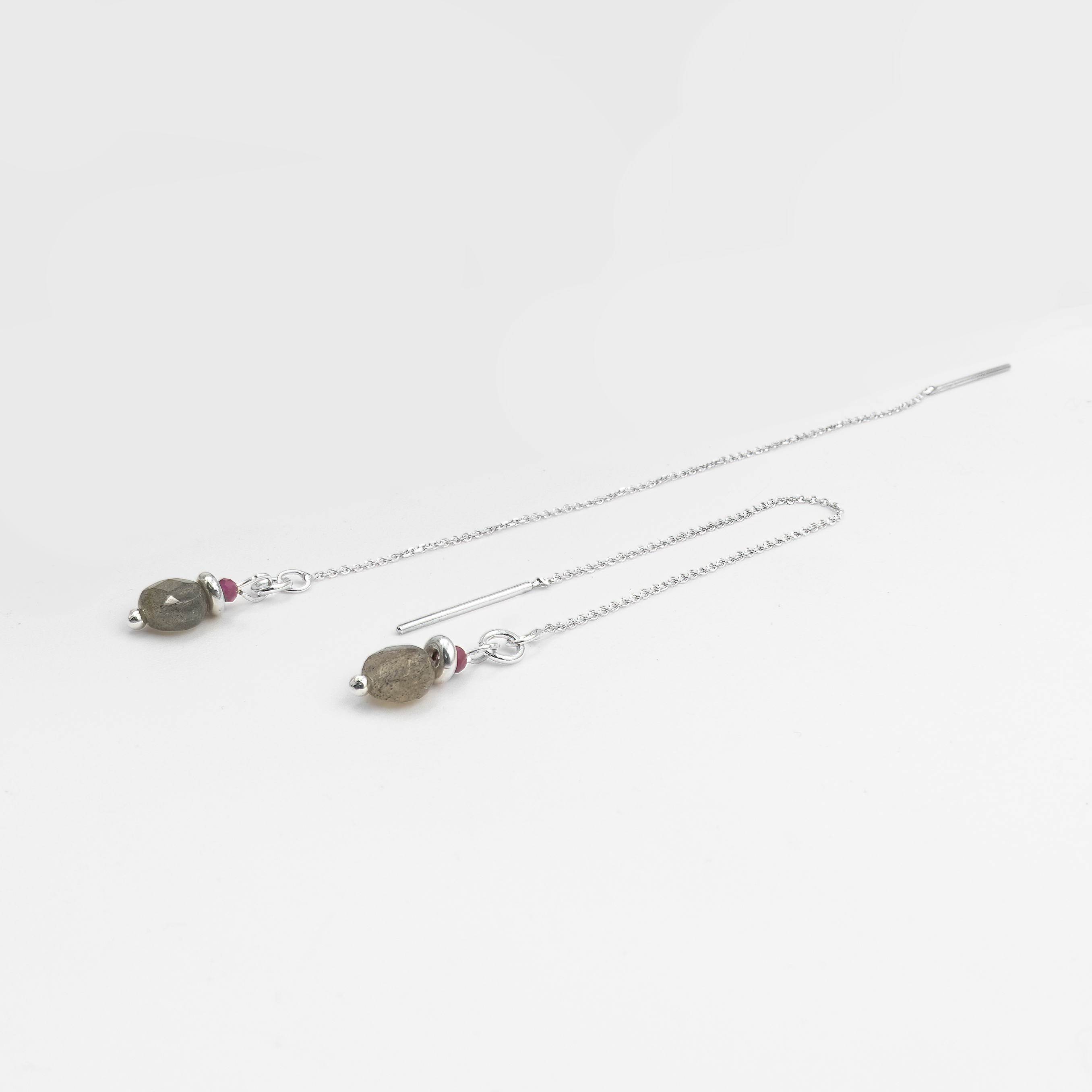 עגילי שרשרת בעבודת יד עם שילוב עוצמתי של לברדורייט ורובי – אבן קסומה בגווני אפור עם הבהובי כחול ואבן אדומה בוהקת. עיצוב שמשלב עומק, מסתורין ותשוקה. תכשיט לנשים שמחפשות סטייל ייחודי, עוצמתי ובלתי מתפשר, עם נגיעה רכה של תנועה ונשיות.

