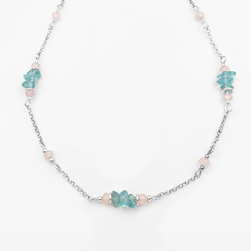 תכשיט מלא קסם בגוונים שקופים ונושמים – שרשרת כסף עם שילוב הרמוני של אפטייט כחול, סמל לרוגע ולבהירות מחשבתית, יחד עם אופליט – אבן עם הילה חלומית שמחזירה אור בצורה רכה ומסתורית. מראה אוורירי, נשי ומתוחכם, מושלם לשילוב עם לבוש בהיר וקווים נקיים.

