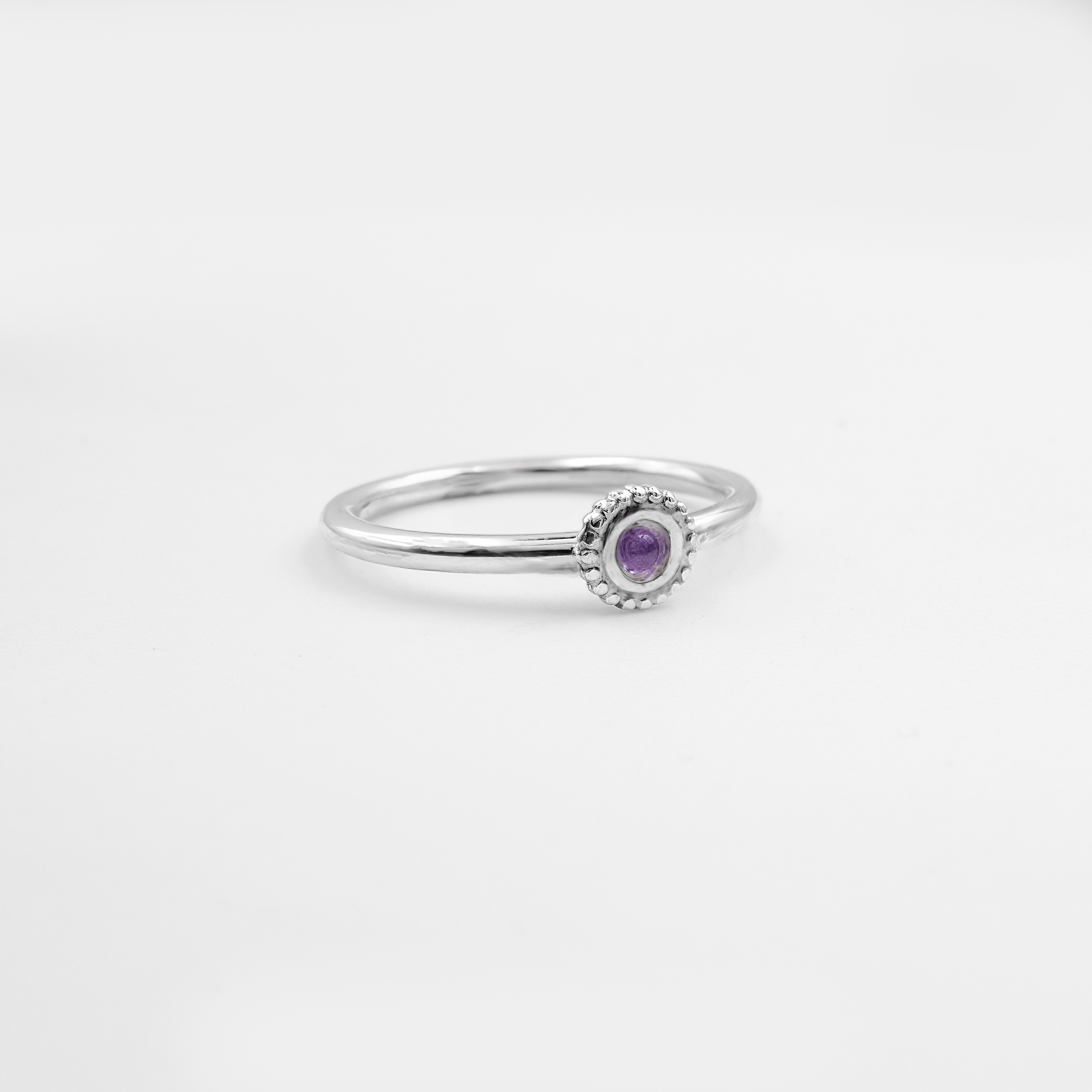 טבעת עדינה מזהב לבן 14 קראט, משובצת אמטיסט בסגנון עגול או אובל, בגוון סגול עמוק עם נגיעות של ויולט. האבן משרה תחושת מסתורין, השראה וחיבור לעולם הרוחני, כשהעיצוב המינימליסטי מדגיש את הנוכחות המלכותית של האבן. מתאימה לאישה עם טעם מיוחד ואופי חזק.

