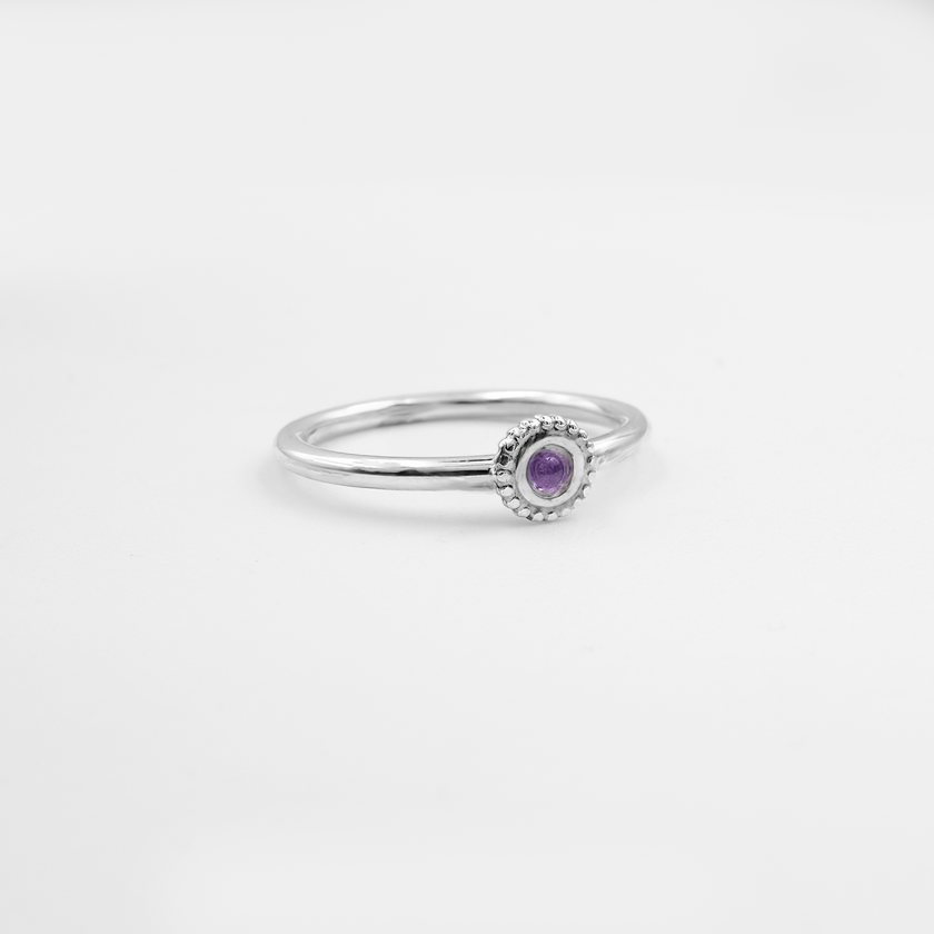 טבעת עדינה מזהב לבן 14 קראט, משובצת אמטיסט בסגנון עגול או אובל, בגוון סגול עמוק עם נגיעות של ויולט. האבן משרה תחושת מסתורין, השראה וחיבור לעולם הרוחני, כשהעיצוב המינימליסטי מדגיש את הנוכחות המלכותית של האבן. מתאימה לאישה עם טעם מיוחד ואופי חזק.

