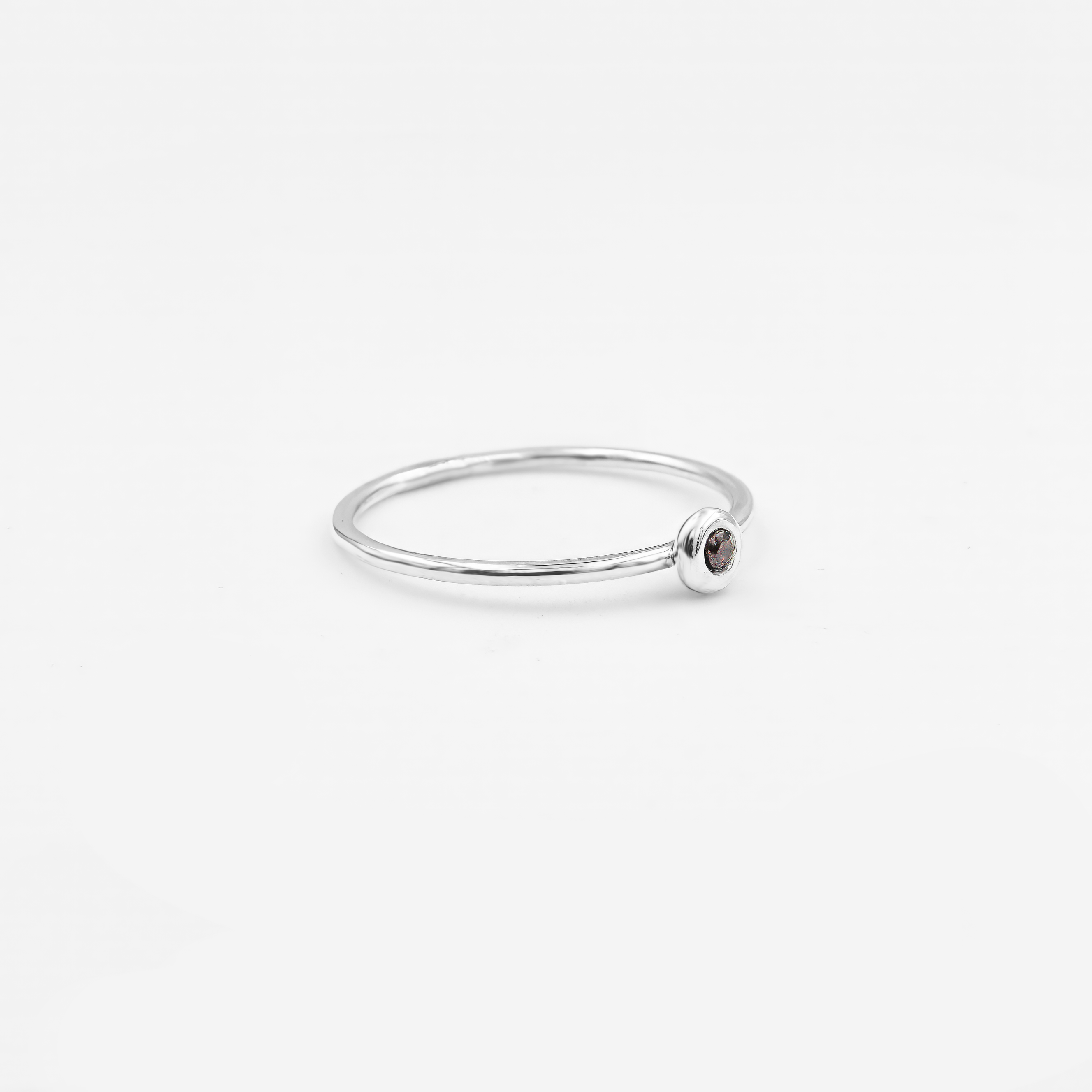 טבעת זהב לבן 14 קראט דקה ועדינה, משובצת באבן רובי קטנה בגוון אדום חם, עם עיצוב מינימליסטי שמקרין נשיות ועדינות. טבעת שמוסיפה נגיעת צבע ותחושת חיות לכל הופעה, תוך שמירה על מראה אלגנטי ופשוט.