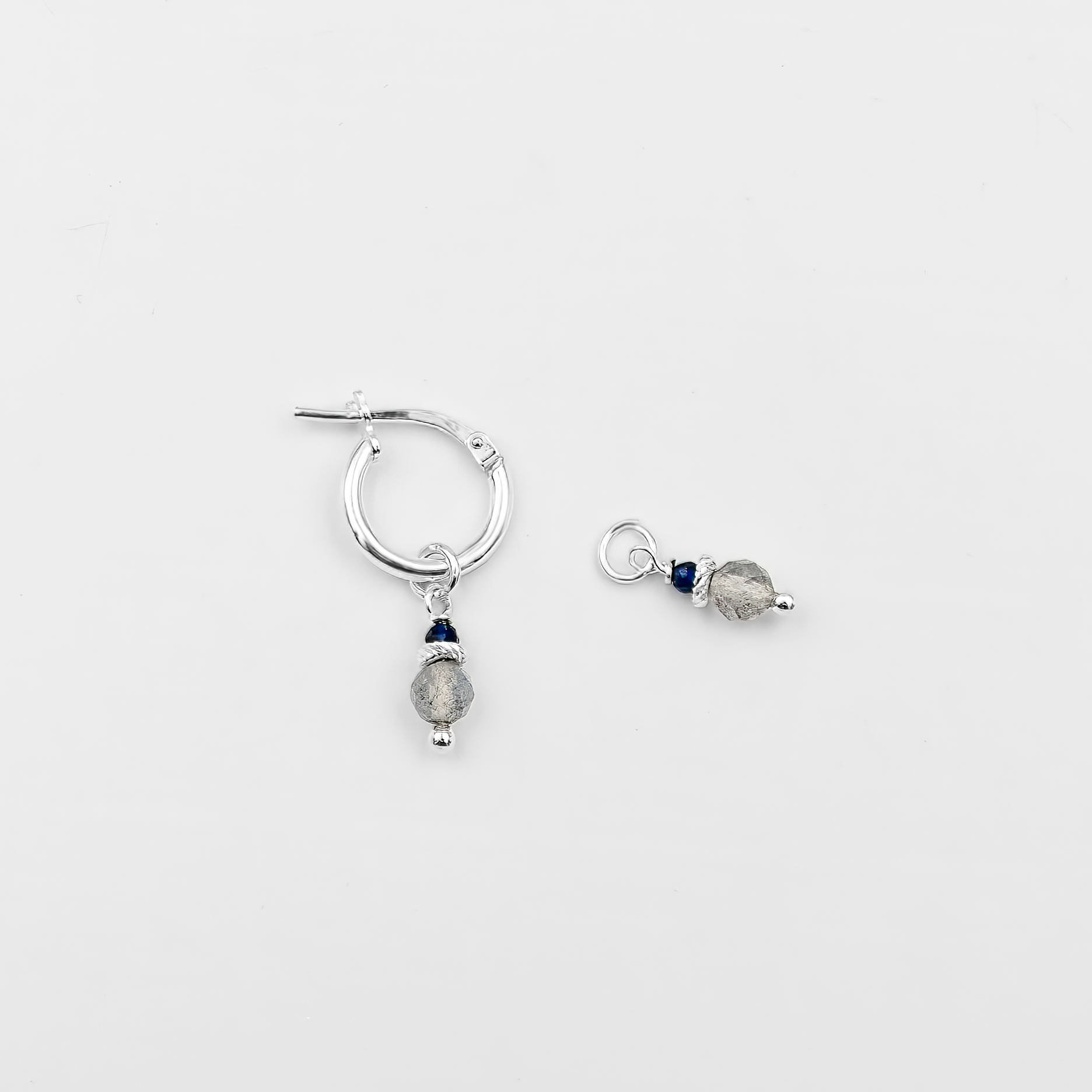 עגילי חישוק מזהב לבן 14 קראט עם צ'ארמים תלויים של לברדורייט וספיר – תכשיט אלגנטי המשלב אבנים בעלות נוכחות ועומק עם עיצוב מודרני ונקי. הלברדורייט הקסום מחליף צבעים באור משתנה, בעוד שהספיר הכחול מוסיף מגע של מלכות. עגילים אלה הם בחירה מושלמת לאירועים מיוחדים, מראה ערב יוקרתי או מתנה אלגנטית לאישה שאוהבת תכשיטים בעלי אופי.

