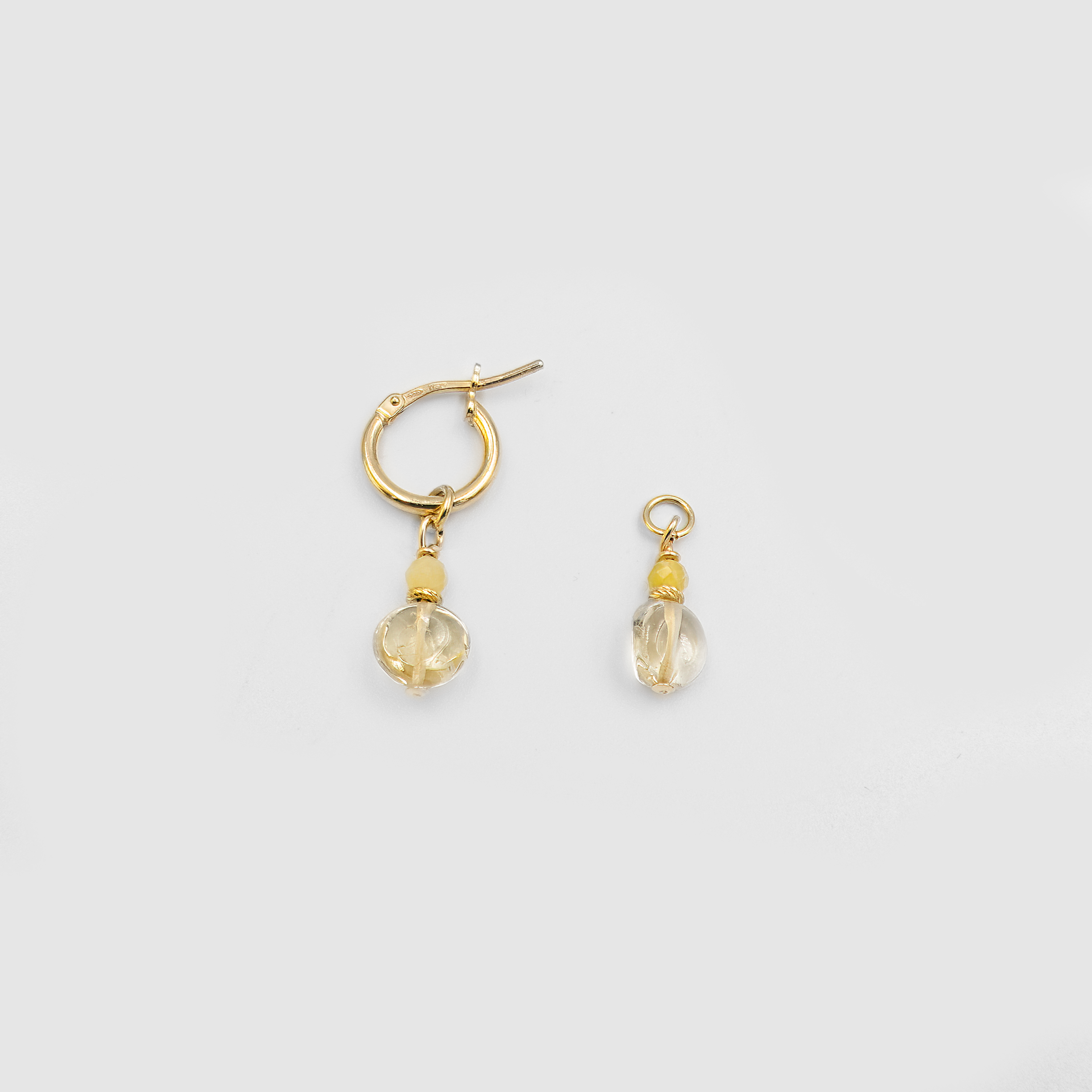 סט עגילי חישוק מזהב אמיתי 14 קראט עם צ'ארמים תלויים של אופל צהוב וסיטרין – תכשיט שמשלב אור, צבע ורכות בעיצוב אחד. האופל מקרין גוונים פנימיים מרהיבים, הסיטרין מוסיף חום שמשי ואופטימיות, והזהב מעניק רקע אלגנטי וזוהר. סט שמאיר את הפנים ומוסיף טאץ' נשי וחגיגי לכל הופעה.

