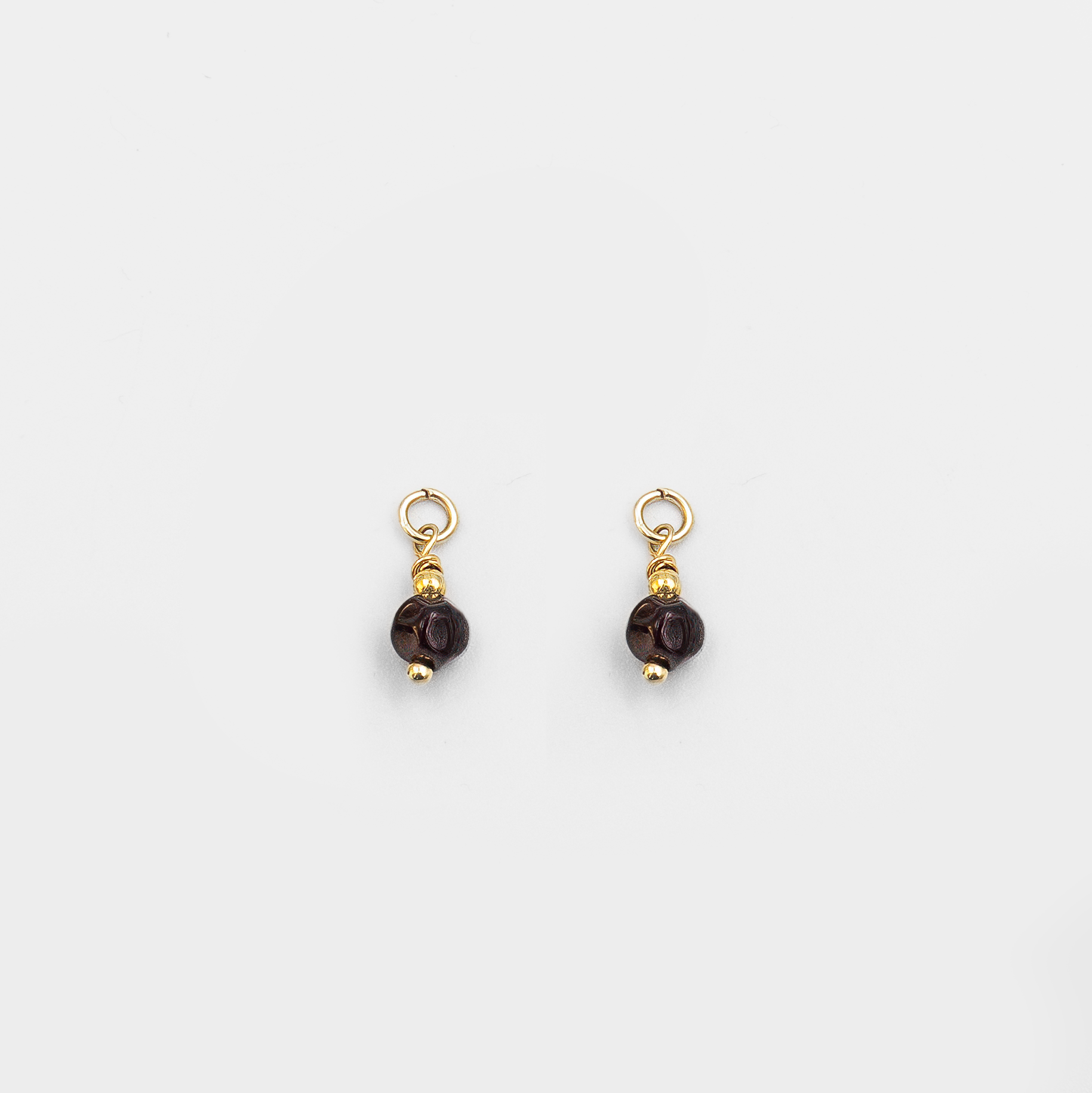 עגילי חישוק מזהב 14 קראט עם צ'ארמים של אבן גארנט – תכשיט בעבודת יד שמשלב בין עדינות לעוצמה. הגארנט מוסיף עומק ומסתורין, בעוד הזהב מביא עמו חום ותשוקה. העיצוב הקלאסי עם נגיעה מודרנית הופך את העגילים למתנה מושלמת לאישה שמעריכה יופי טבעי ואיכות בלתי מתפשרת.

