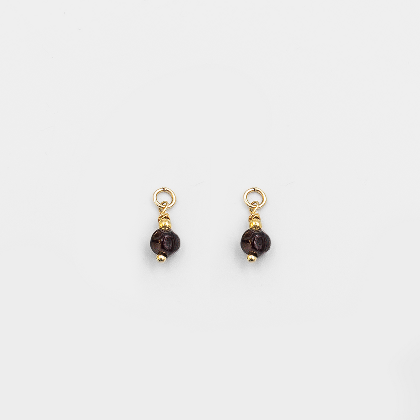 עגילי חישוק מזהב 14 קראט עם צ'ארמים של אבן גארנט – תכשיט בעבודת יד שמשלב בין עדינות לעוצמה. הגארנט מוסיף עומק ומסתורין, בעוד הזהב מביא עמו חום ותשוקה. העיצוב הקלאסי עם נגיעה מודרנית הופך את העגילים למתנה מושלמת לאישה שמעריכה יופי טבעי ואיכות בלתי מתפשרת.

