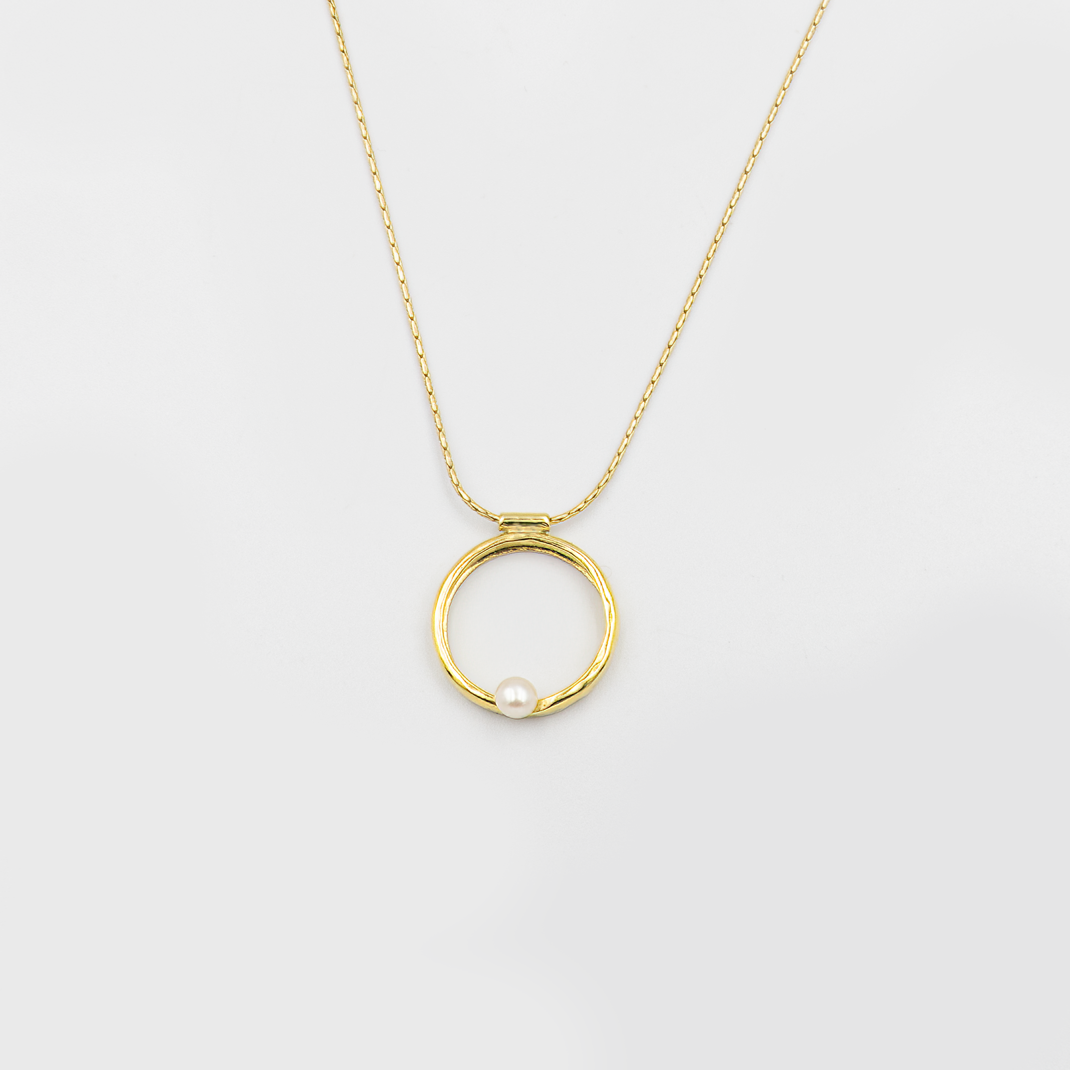 שרשרת בעיצוב אלגנטי עם תליון מרשים בצבע זהב חם, המשובץ בפנינת שמנת מעודנת – תכשיט קלאסי בעל נוכחות בולטת. הפנינה ממוקמת במרכז התליון ומקרינה אור רך וטבעי, תוך יצירת ניגוד מחמיא עם הציפוי הזהוב. עיצוב השרשרת משלב בין איזון בין רכות יוקרתית לאופנה עדכנית, ומתאים לאירועים חגיגיים כמו גם ללבוש יומיומי עם נגיעה נשית. פנינים ידועות כמזכירות יופי טבעי ופשטות אלגנטית – ויחד עם הזהב, נוצרת הרמוניה מושלמת בין אלגנטיות לחמימות.