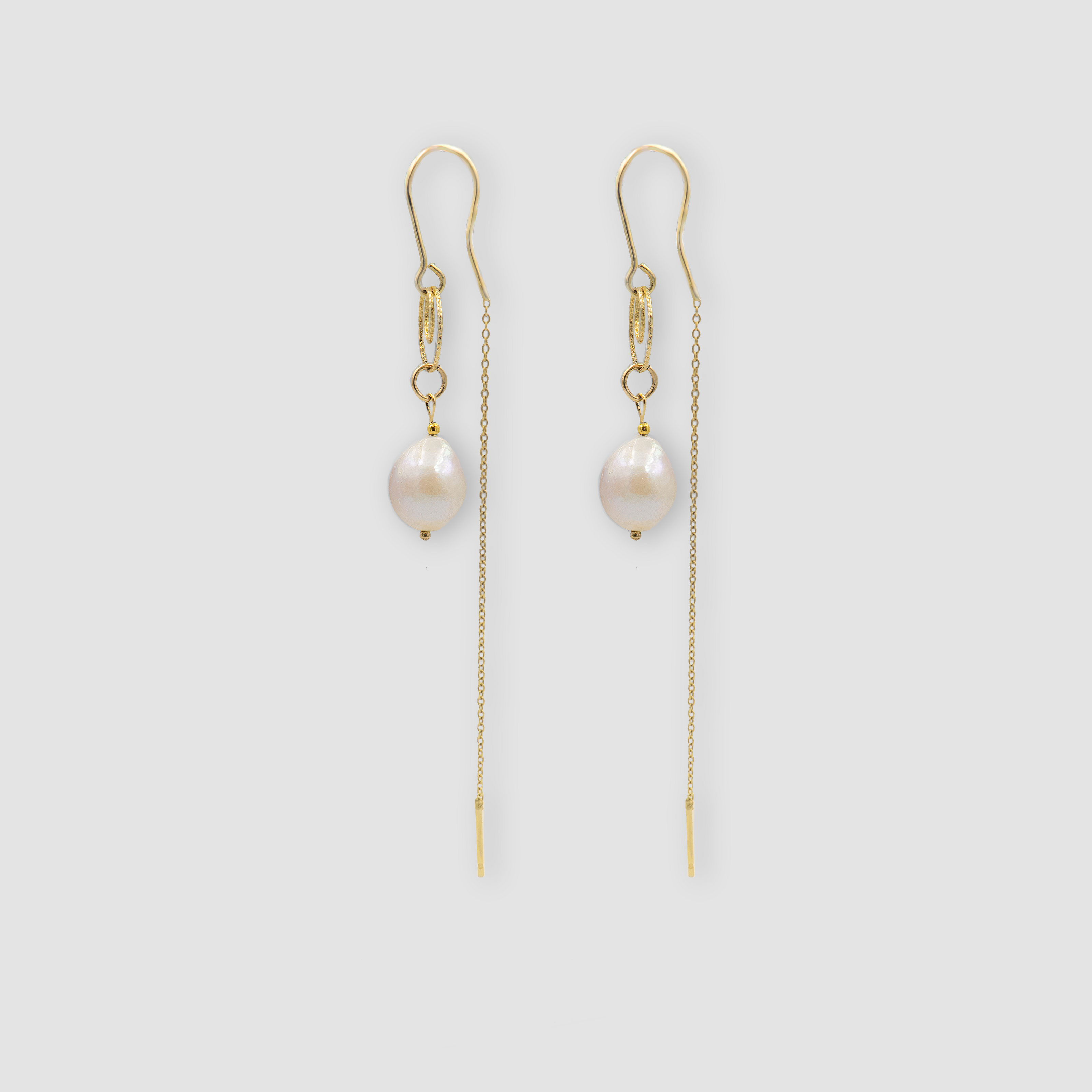 עגילי פנינה לבנה בעיצוב תלוי, מחוברים לשרשרת דקה ונשית שמוסיפה מגע מודרני. פנינים לבנות מסמלות התחלה חדשה וטוהר – מה שהופך את העגילים האלה לאידיאליים לכלות או לאימהות ביום החתונה. עגילים עם אופי רגשי עדין ונוכחות אלגנטית ונשית.

