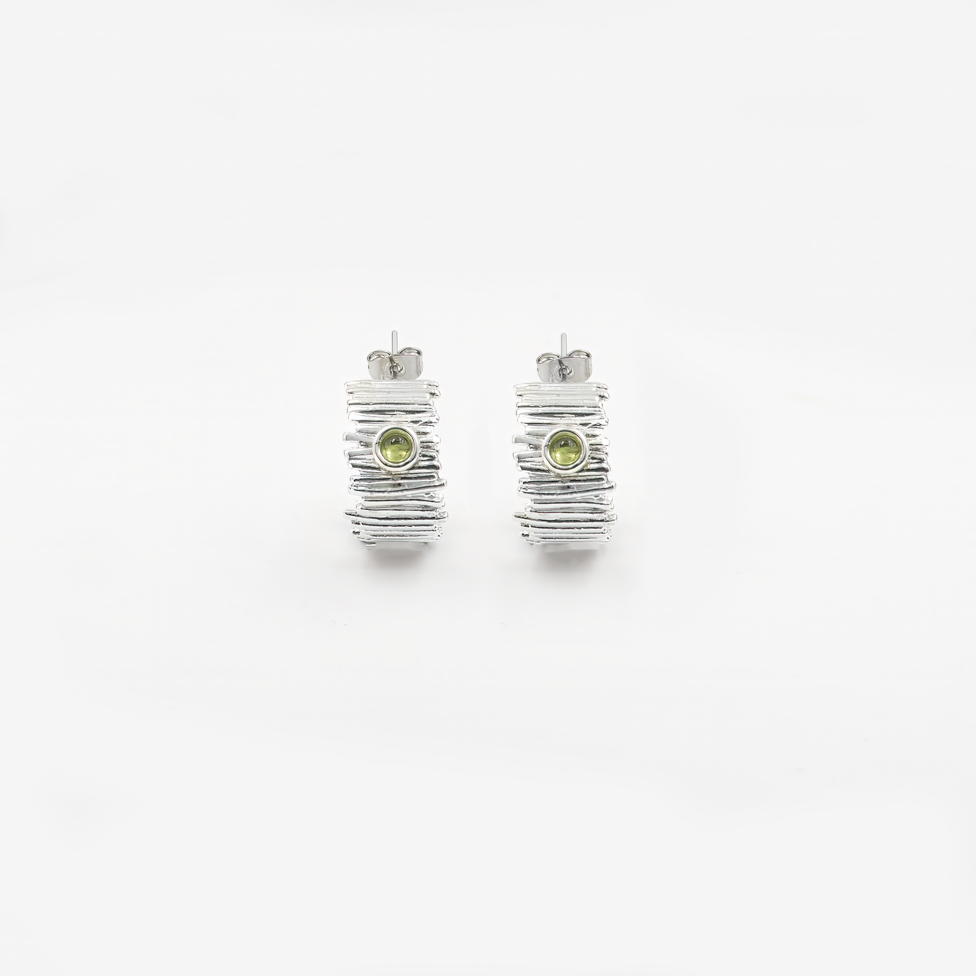 עגילי חישוק מכסף סטרלינג 925 עם אבני פרידוט ירוקות – תכשיט בעיצוב טבעי, רענן ומלא אור. הפרידוט, אבן הלידה של חודש אוגוסט, מסמל שמחה, שפע והתחדשות, והוא ידוע כאבן שמביאה עמה אנרגיה חיובית ואיזון רגשי. הגוון הירוק-בהיר של האבן משתלב בהרמוניה עם הברק הקריר של הכסף ויוצר תכשיט עדין אך בעל נוכחות. חישוקים קלילים ונוחים ללבישה, עם סגירה בטוחה וגימור איכותי. מתאימים להופעה יומיומית מוקפדת, לאירועים, או כמתנה לאישה שמחוברת לטבע, לעדינות ולסטייל אישי.

