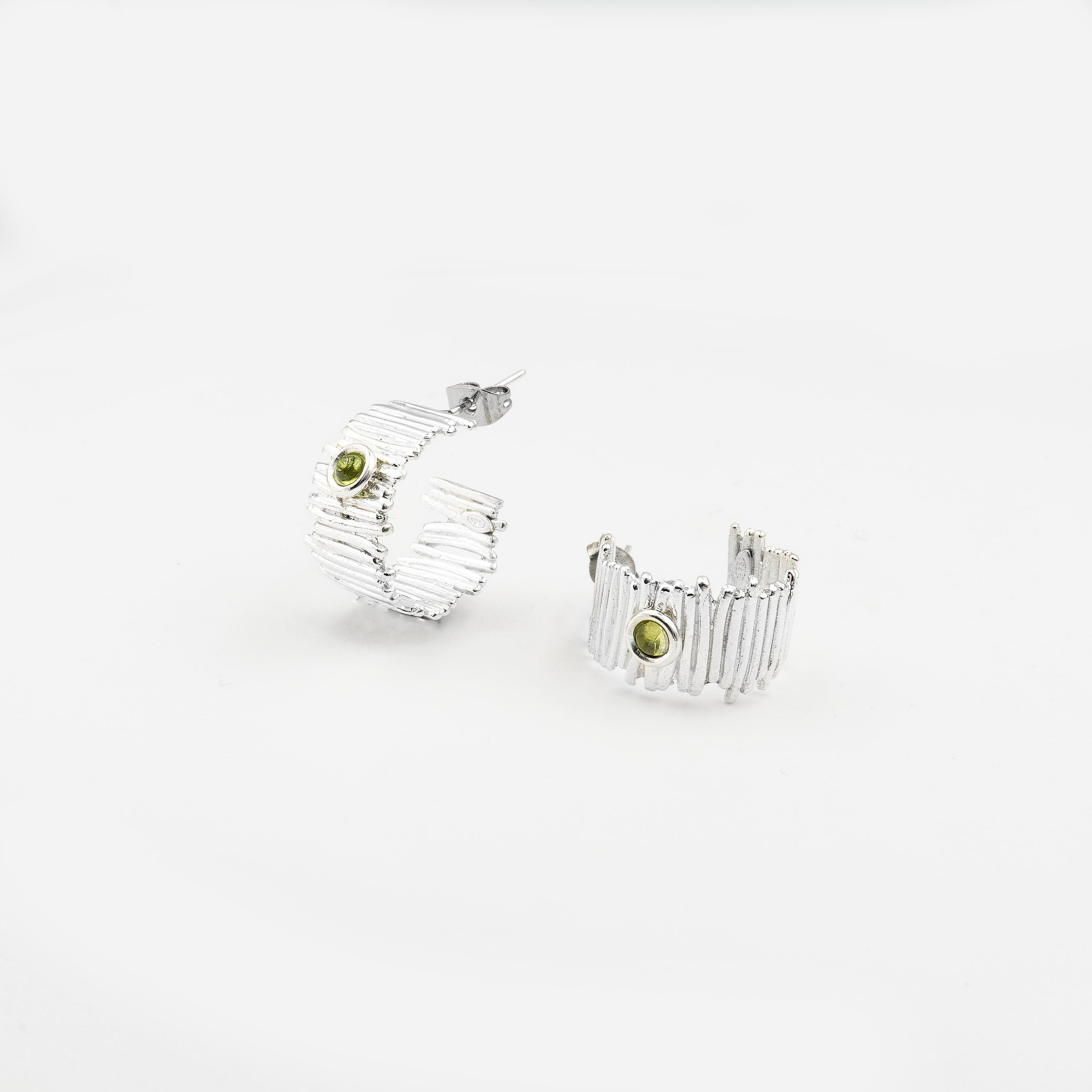 עגילי חישוק בעבודת יד מכסף 925 משובצים בפרידוט – תכשיט בעיצוב עדין ונשי, שמשלב מראה טבעי עם תחושת רעננות נעימה. אבן הפרידוט, בגוון ירוק-לימוני, מוסיפה מגע צבעוני ורך לעגיל המעוגל, ויוצרת מראה מתוחכם שאינו מתאמץ. מתאימים לכל גיל ולכל סגנון לבוש – החל מלוק קז'ואלי ועד לבוש ערב קליל. הפרידוט נחשב גם לאבן שמחזקת ביטחון עצמי ותחושת שמחה, מה שהופך את העגילים למתנה מושלמת לאירועים משמחים או כפינוק אישי עם משמעות.

