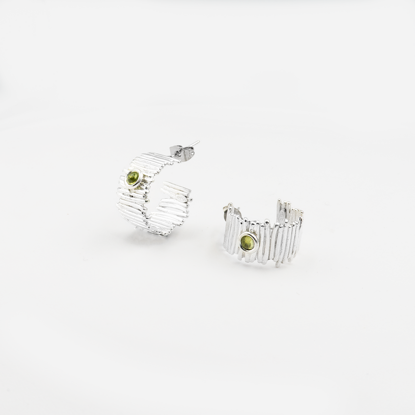 עגילי חישוק בעבודת יד מכסף 925 משובצים בפרידוט – תכשיט בעיצוב עדין ונשי, שמשלב מראה טבעי עם תחושת רעננות נעימה. אבן הפרידוט, בגוון ירוק-לימוני, מוסיפה מגע צבעוני ורך לעגיל המעוגל, ויוצרת מראה מתוחכם שאינו מתאמץ. מתאימים לכל גיל ולכל סגנון לבוש – החל מלוק קז'ואלי ועד לבוש ערב קליל. הפרידוט נחשב גם לאבן שמחזקת ביטחון עצמי ותחושת שמחה, מה שהופך את העגילים למתנה מושלמת לאירועים משמחים או כפינוק אישי עם משמעות.

