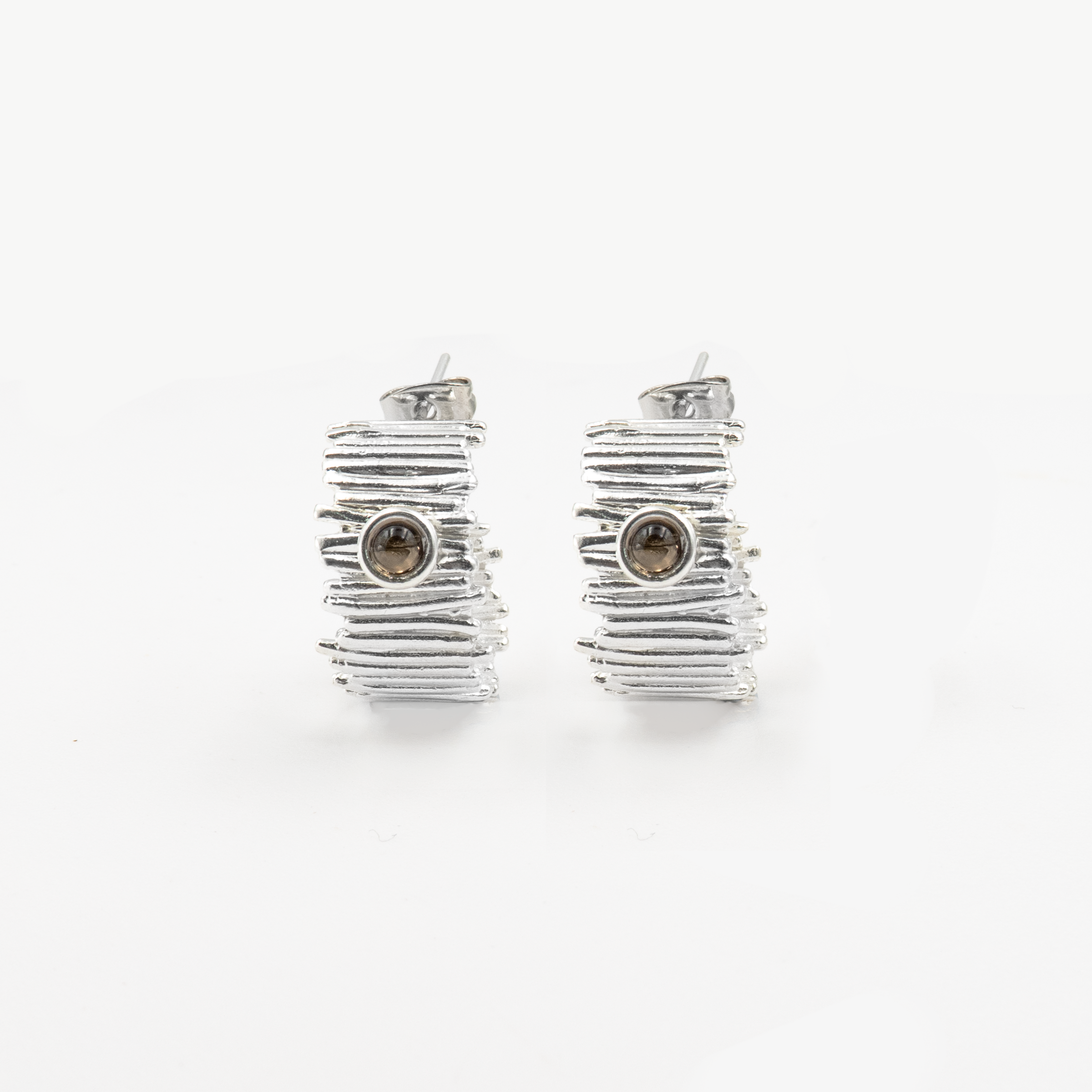 עגילי חישוק מכסף סטרלינג 925 עם סמוקי טופז – שילוב ייחודי של אלגנטיות טבעית ועיצוב מינימליסטי עם נוכחות. סמוקי טופז, בגווני חום-שוקולד מעושן, מעניק לעגיל מראה חמים, עמוק ומסתורי. האבן ידועה ככזו שמחזקת קרקוע, בהירות מחשבתית ויציבות רגשית. חישוקי הכסף המעודנים יוצרים מסגרת מושלמת לאבן, ומאפשרים לה לבלוט בעדינות. מתאימים לנשים שאוהבות עיצוב מתוחכם שאינו צועק – אלא לוחש שיק. עגילים נוחים, קלילים ומתאימים ליום ולערב, מגיעים באריזת מתנה קלאסית – מוכנים לרגע מיוחד.

