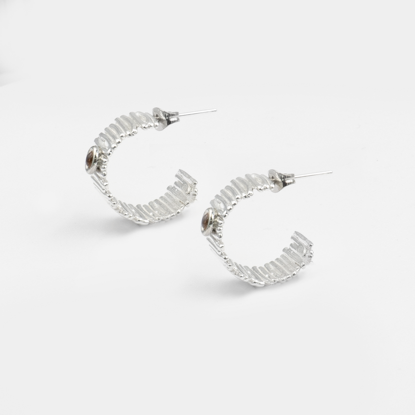 עגילי חישוק בעבודת יד מכסף טהור 925 עם אבן סיטרין בגוון זהב רך – פריט מיוחד לאוהבות מראה עדין עם נגיעת צבע חמה. הסיטרין מביא איתו שמחת חיים, חום פנימי ותחושת פתיחות, מה שהופך את העגילים לבחירה מושלמת לנשים שרוצות לשדר ביטחון וקסם אישי. תכשיט שמתאים לעונה החמה אך גם מחמם מראה חורפי – משתלב עם כל גווני העור והלבוש. העיצוב האלגנטי מבטיח התאמה לכל סגנון – קז’ואל, בוהו או ערב אלגנטי. מתנה נפלאה ליום הולדת, חג או פינוק לנשמה.

