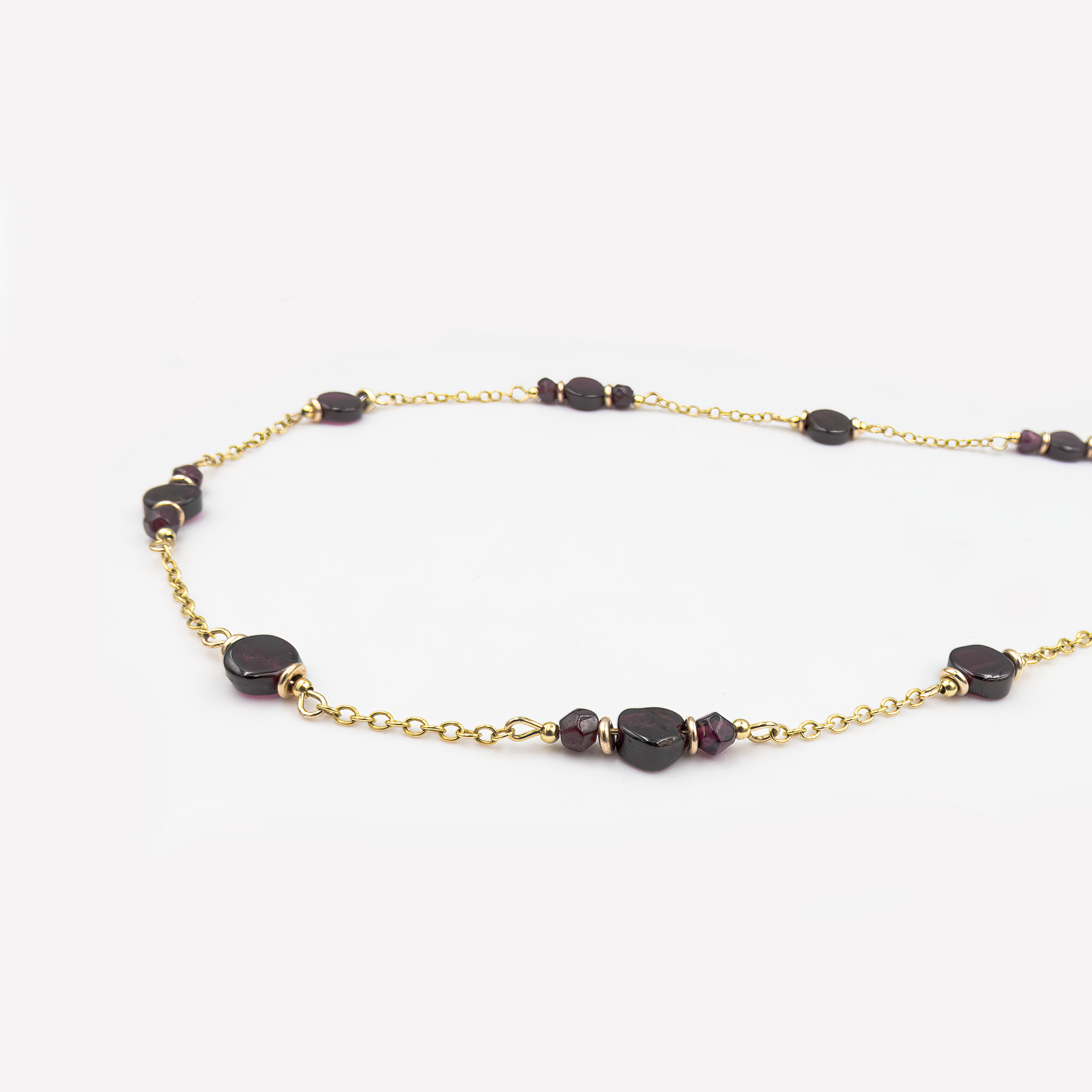 קלוז־אפ של שרשרת עדינה עשויה זהב 14 קראט עם אבן גארנט טבעית בליטוש עגול. הצבע האדום־עמוק של האבן מהדהד רגשות של אהבה עמוקה וביטחון פנימי. הזהב החם מחמיא לגוון האבן ויוצר מראה אלגנטי ונשי. תכשיט בעיצוב נקי ששם דגש על איכות, אנרגיה וסטייל אישי. מתאים לנשים שמעדיפות תכשיטים עם נוכחות שקטה ומשמעותית. פריט מושלם לאוסף תכשיטים איכותיים עם סיפור.