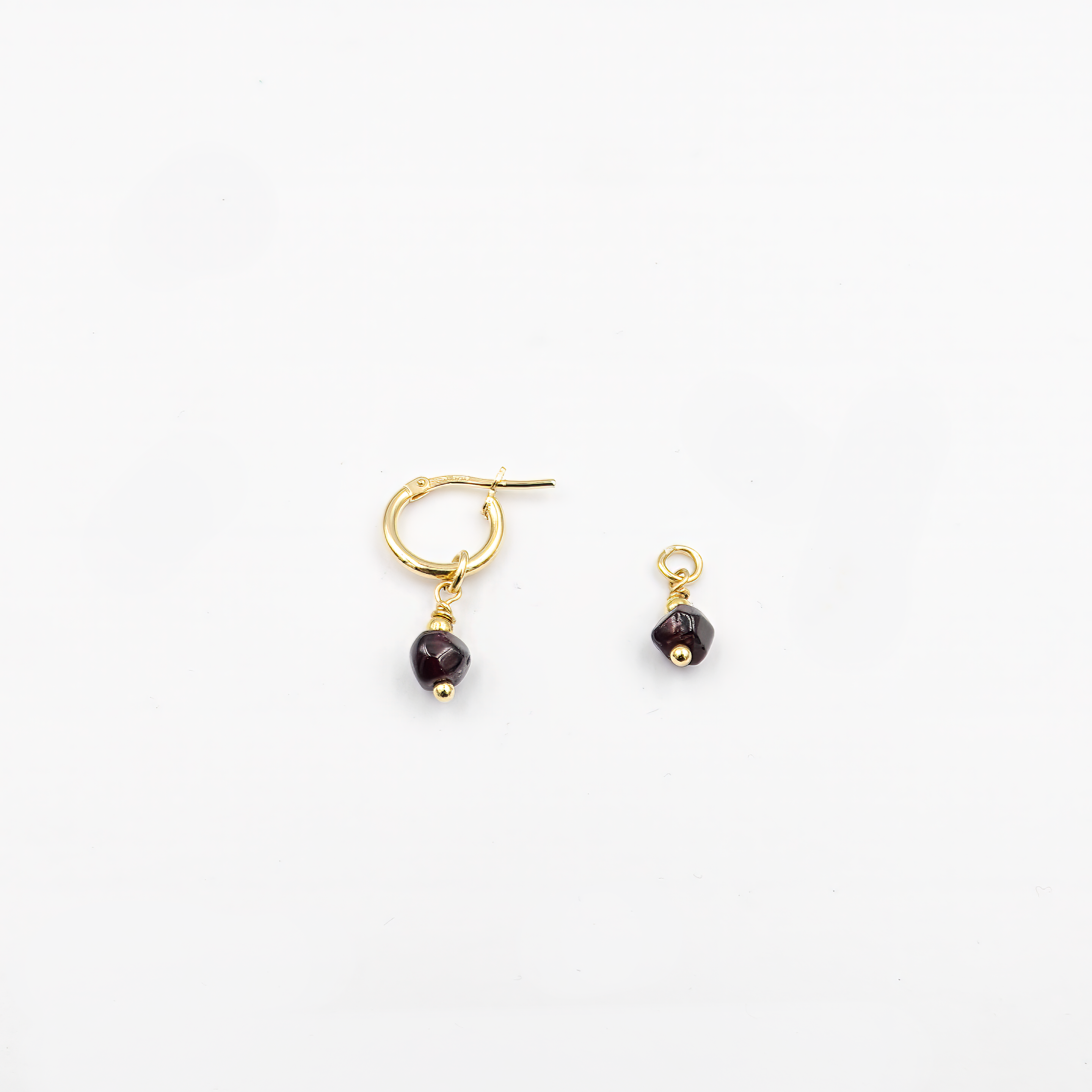 עגילי חישוק מזהב 14 קראט עם תליון אבן גארנט – תכשיט בעיצוב מודרני שמשלב בין יוקרה לטבעיות. הגארנט, עם הברק הפנימי הייחודי שלו, משתלב בהרמוניה עם הזהב, ליצירת מראה אלגנטי ומרשים. עגילים קלים ונוחים לענידה, מתאימים לכל סגנון לבוש ולכל אירוע.

