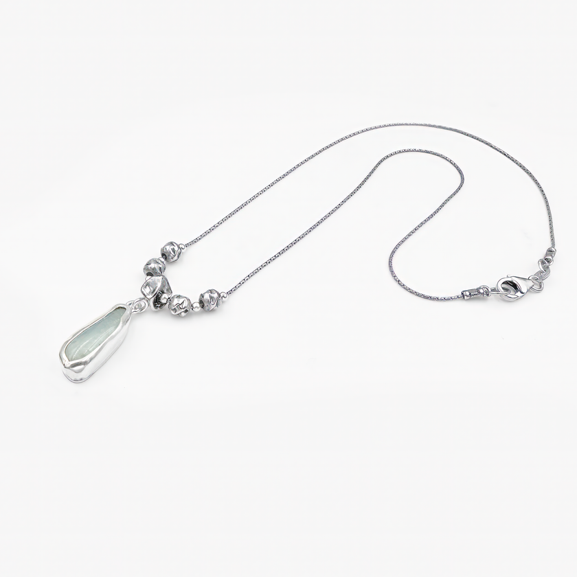 שרשרת נשית ומעודנת מכסף, הכוללת תליון אבן חצי-יקרה בגוון ירקרק-תכלכל הנתון במסגרת כסף אורגנית. בחלקה העליון של השרשרת שורת חרוזי כסף בעיבוד אמנותי מעניקים לה מראה ייחודי. עיצוב עכשווי עם נגיעה בוהמיינית, אידיאלי לשילוב עם בגדים בגוונים טבעיים.