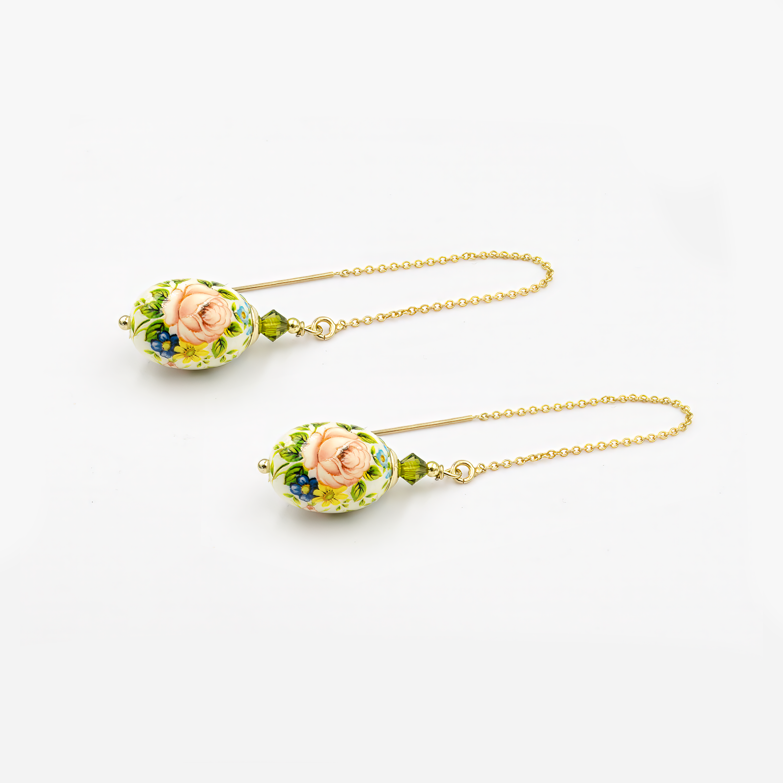 עגילי שרשרת תלויים עם חרוז אמייל בגוון ירוק בהיר, בעיצוב אוורירי ונשי במיוחד. השרשרת הדקה יוצרת תנועה אלגנטית סביב הפנים, והחרוז הירוק מוסיף נקודת צבע עליזה ומעודנת. מתאימים למראה יומיומי עם נגיעת רעננות, או כתוספת קלילה לשמלה חגיגית.

