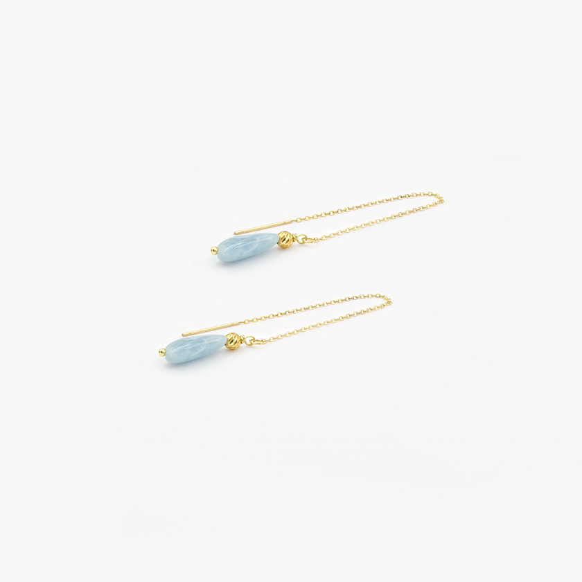 עגילים תלויים עם תנועה אלגנטית, עשויים זהב לבן 14 קראט בשילוב תליון אקוומרין טבעי. עיצוב מדויק ועדין שמשלב את השקיפות הצלולה של האקוומרין עם הברק המלכותי של הזהב הלבן. עגיל שמתאים לאישה שמחפשת את האיזון בין תחכום לפשטות, בין קלאסיות לנוכחות אישית – תכשיט שהוא גם תוספת סטייל וגם ביטוי פנימי של רוגע וחיבור לעצמך.