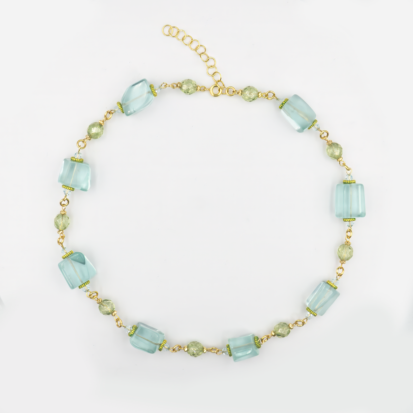 שרשרת בעבודת יד עם חרוזים כחולים בגוונים עזים ומרקמים מגוונים – חלקם שקופים כקרח, אחרים בעלי עומק פנימי מרהיב. העיצוב כולל חיבורים עדינים בגוון זהב שמוסיפים חמימות לאפקט הקריסטלי של החרוזים. תכשיט שמשרה תחושת קלילות, ים, וחופש, אך גם יוקרה ואישיות. מושלם לשדרוג מראה קיץ או מתנה ייחודית לאישה שאוהבת תכשיטים עם נוכחות.

