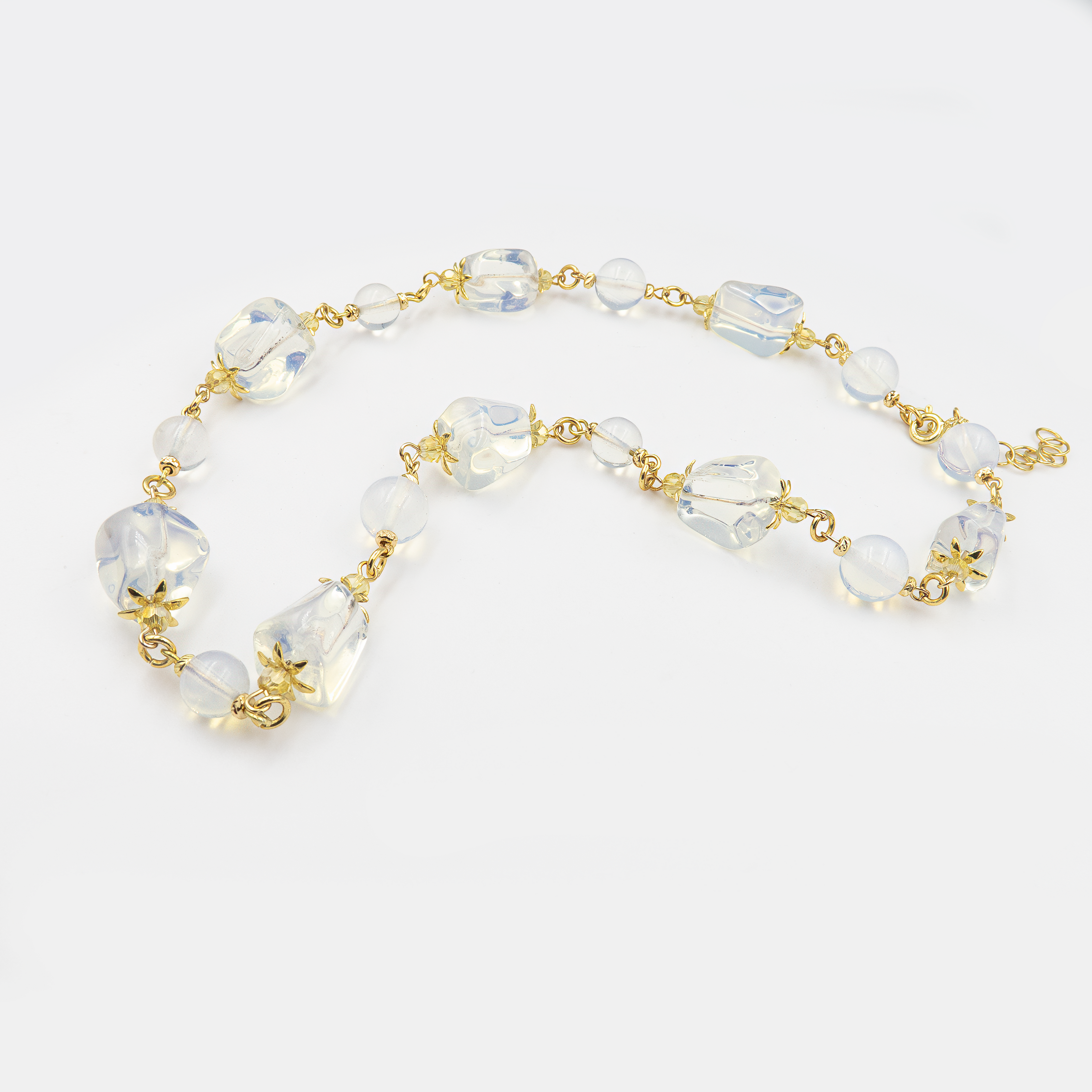 ענק בעבודת יד עם שילוב מרהיב של מונסטון ואופליט – אבנים בגווני לבן חלבי, כחלחל פנינתי וזוהר שקוף שמפיץ אור רך. האבנים מונחות ברכות על הצוואר ומזכירות אור ירח בשמי לילה. תכשיט מלא עדינות ומסתורין, מושלם לנשים שמחפשות יופי עם עומק רגשי ואנרגטי.

