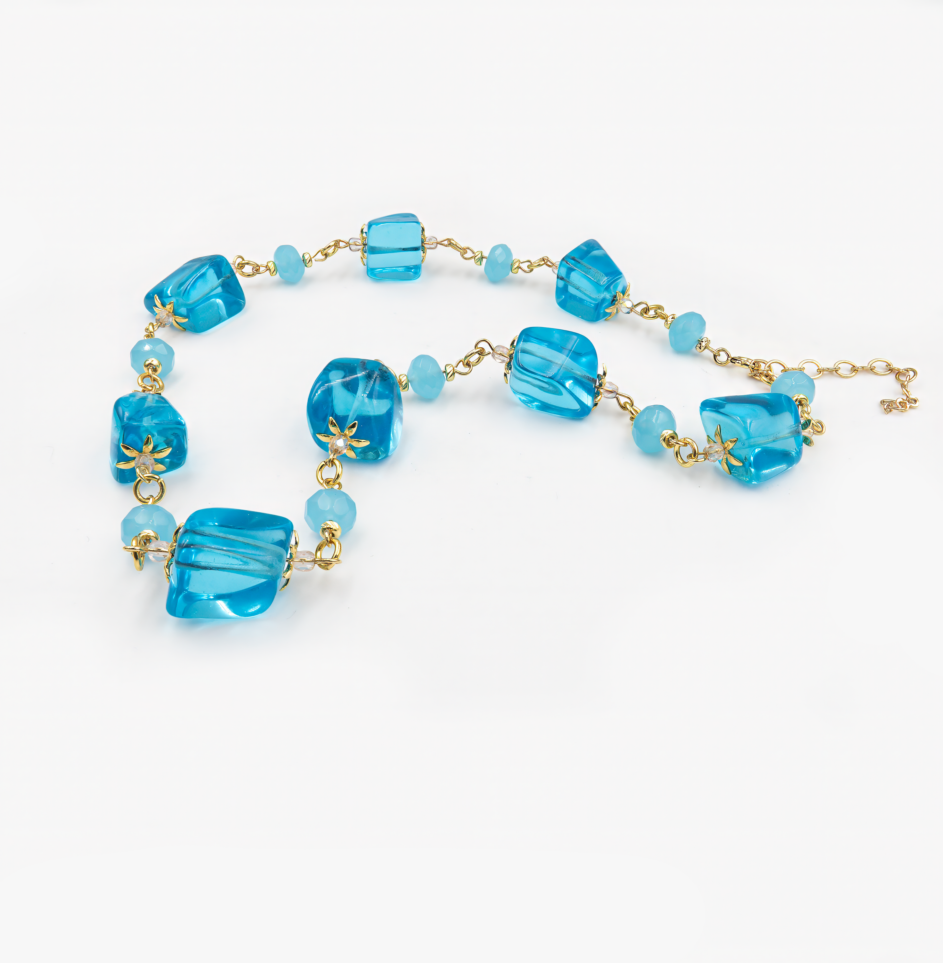 קולר בעבודת יד עם חרוזים כחולים שקופים במראה קריסטלי בשילוב חלקי מתכת מוזהבים. עיצוב קליל, צבעוני ובוהק שמזכיר מים צלולים ושמש זהובה. תכשיט ייחודי ומלא חיים שמוסיף טאץ' רענן וקיצי לכל לוק, ומתאים גם כמתנה מיוחדת.