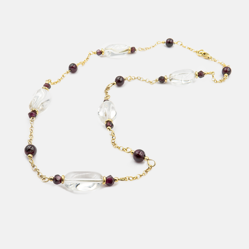 תקריב של תכשיט ייחודי – שרשרת זהב אמיתי 14 קראט עם שני תליונים קטנים: גארנט בוהק ורוק־קריסטל שקוף. השילוב בין הצבע האדום העמוק לבין הזוהר השקוף יוצר קונטרסט מרהיב אך עדין, שמסמל גם אנרגיה רגשית וגם בהירות רוחנית. עיצוב מינימליסטי ואלגנטי, עשוי בעבודת יד, ומתאים לכל מי שמחפשת תכשיט עם משמעות עמוקה, מראה קלאסי ונוכחות רכה עם קריצה אישית.